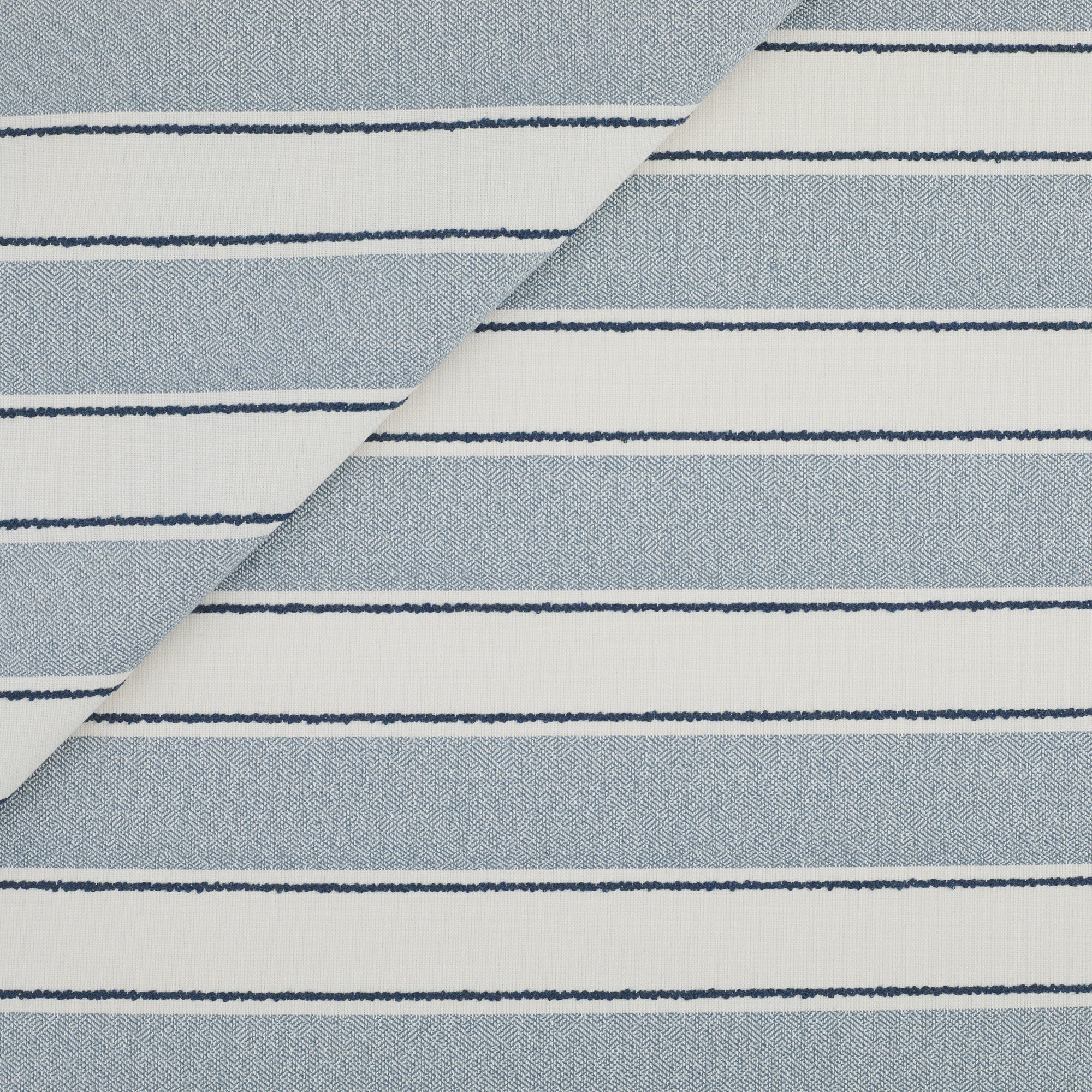 Tonic Living Sentiment Sunbrella Denim indoor/outdoor upholstery fabric featuring a wide stripe with navy accents.
