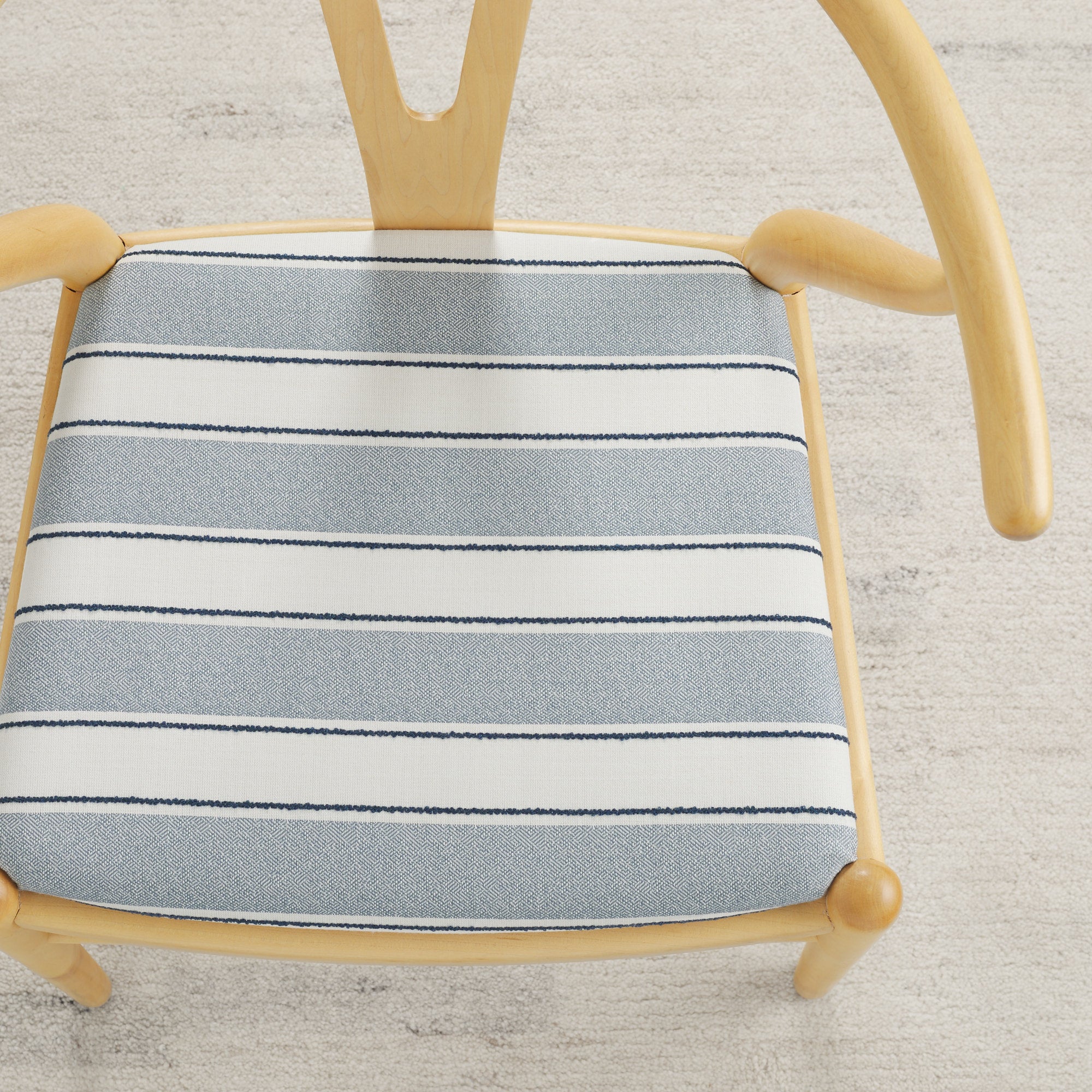 Tonic Living Sentiment Sunbrella Denim indoor/outdoor upholstery fabric on a dining chair seat in blue and white stripe.