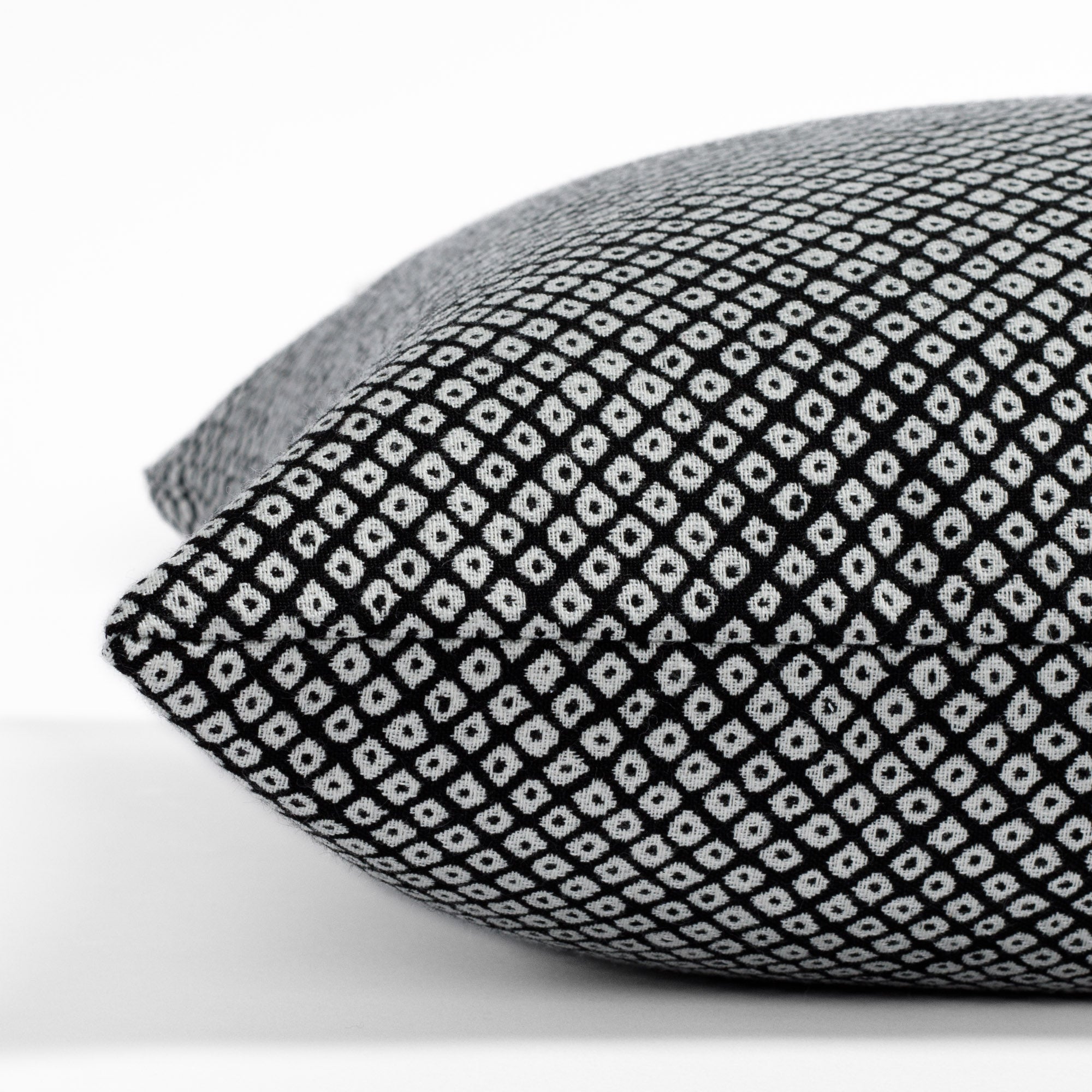 Shibori Classic, a black and white dotted pattern indoor/outdoor pillow from Tonic Living: close-up side view.