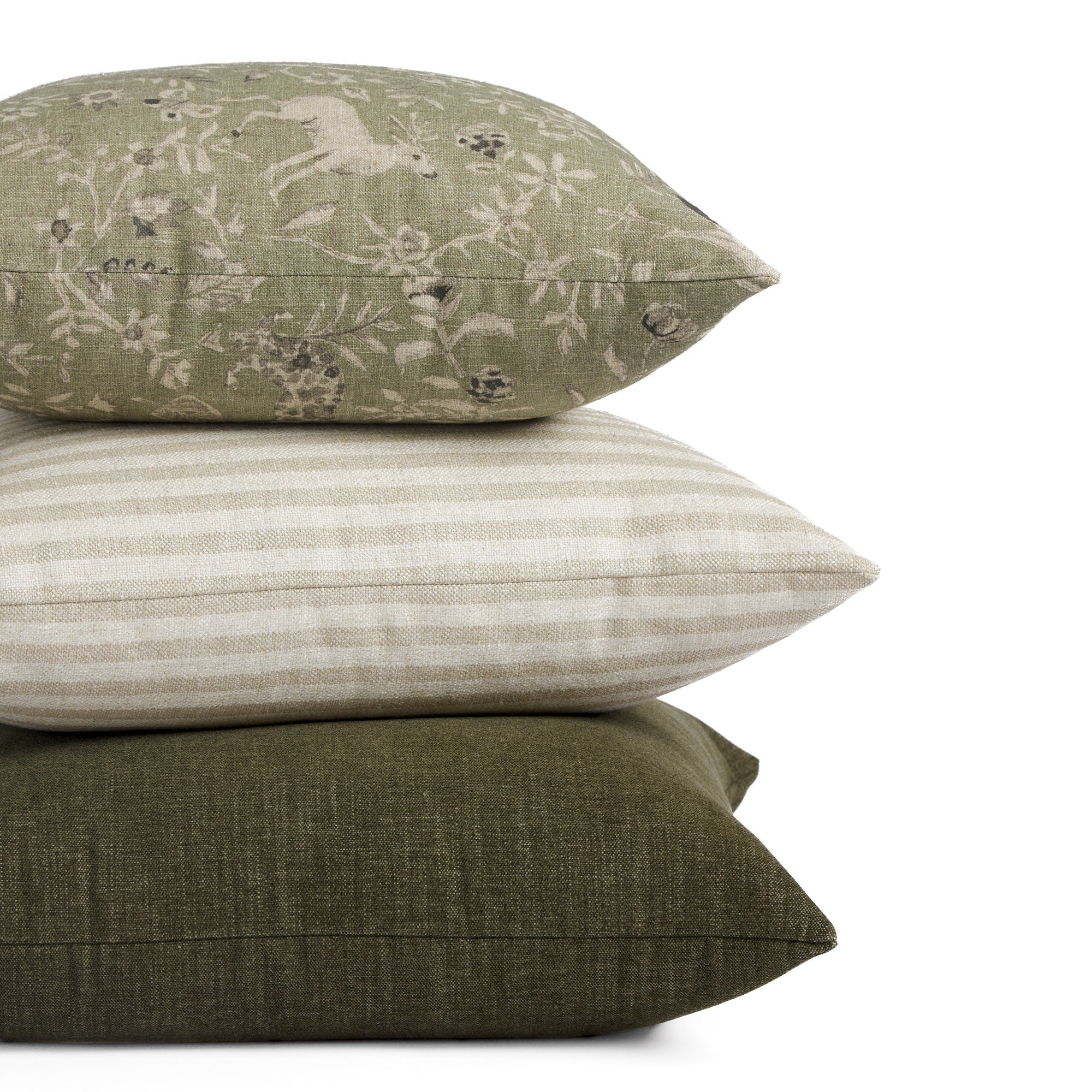 Stack of Tonic Living pillows including Cyprus Moss, Somerset Stripe Oatmeal, and Bedford Moss in green and neutral tones.