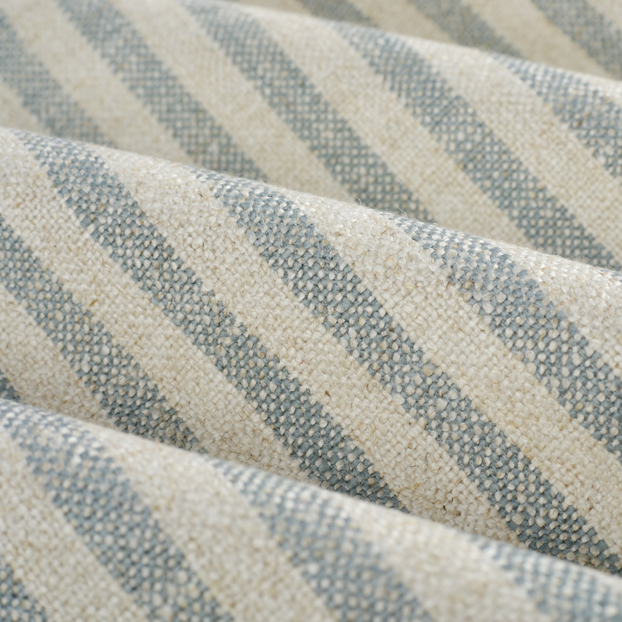 Close up of Tonic Living Somerset Stripe Sky Blue fabric showing light blue and beige vertical stripe detail.