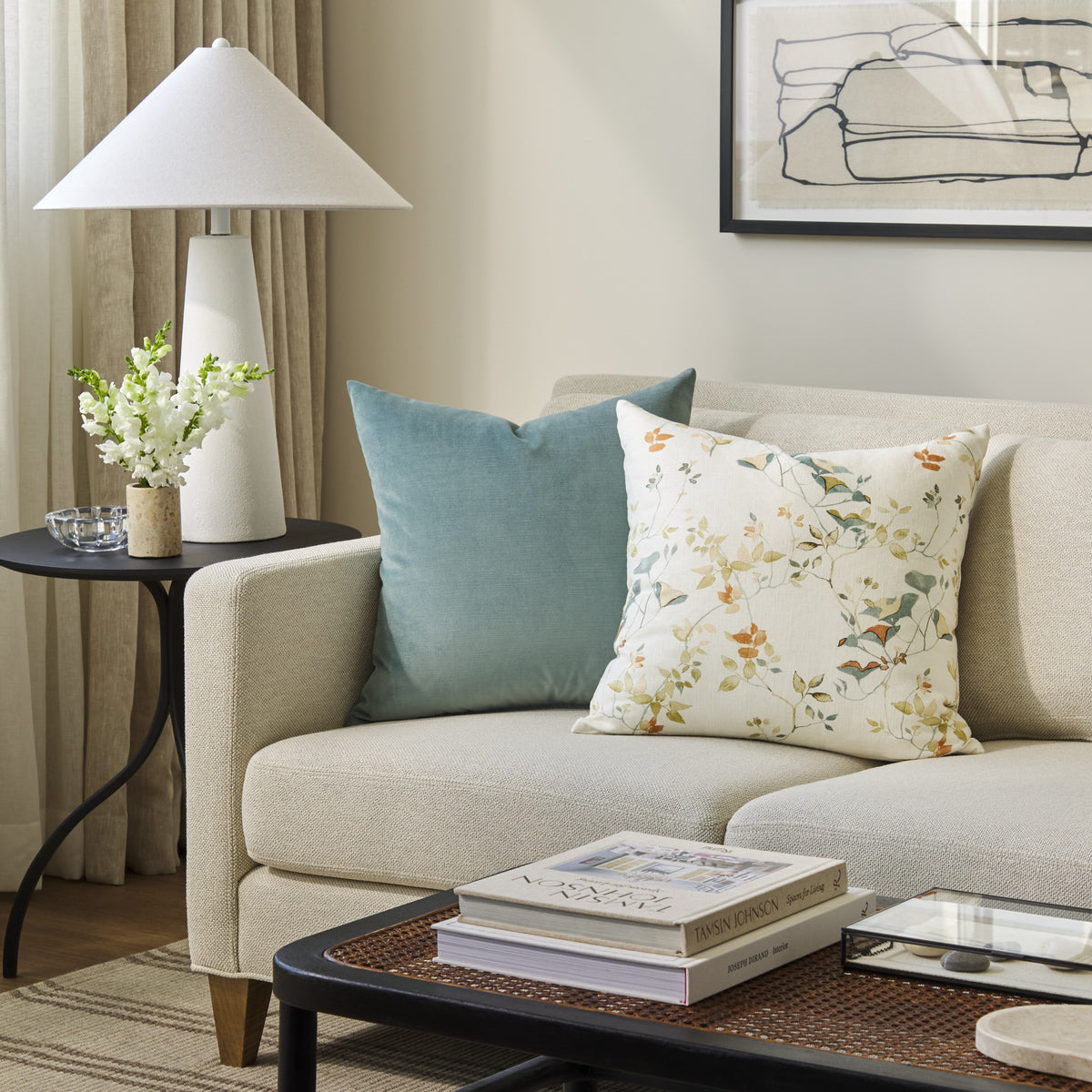 Tonic Living Sterling Velvet Lake aqua blue pillow styled on a sofa with a floral decorative cushion in a living room.