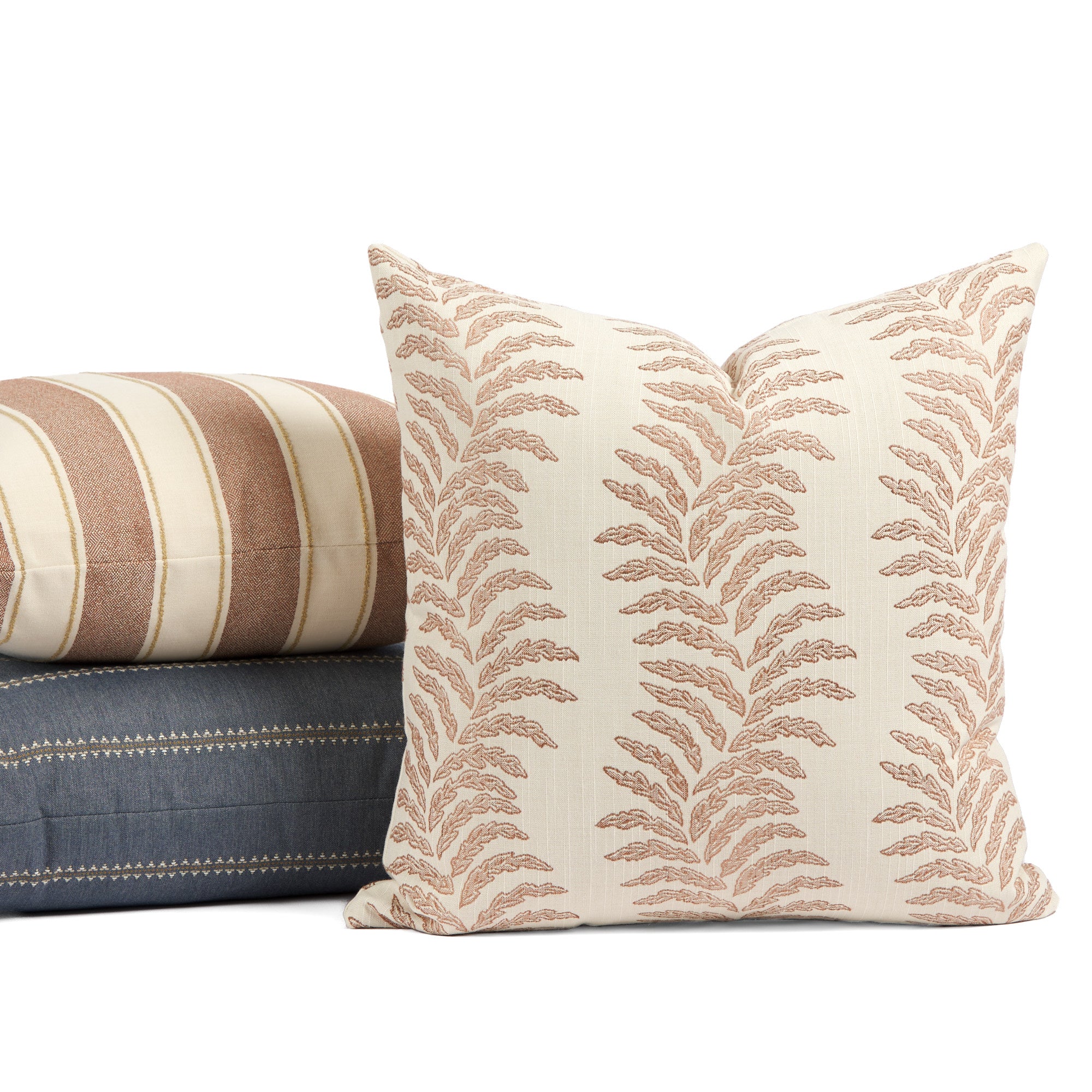 Tonic Living Sentiment Terracotta outdoor cushion styled in front of cream and blue throw pillows.