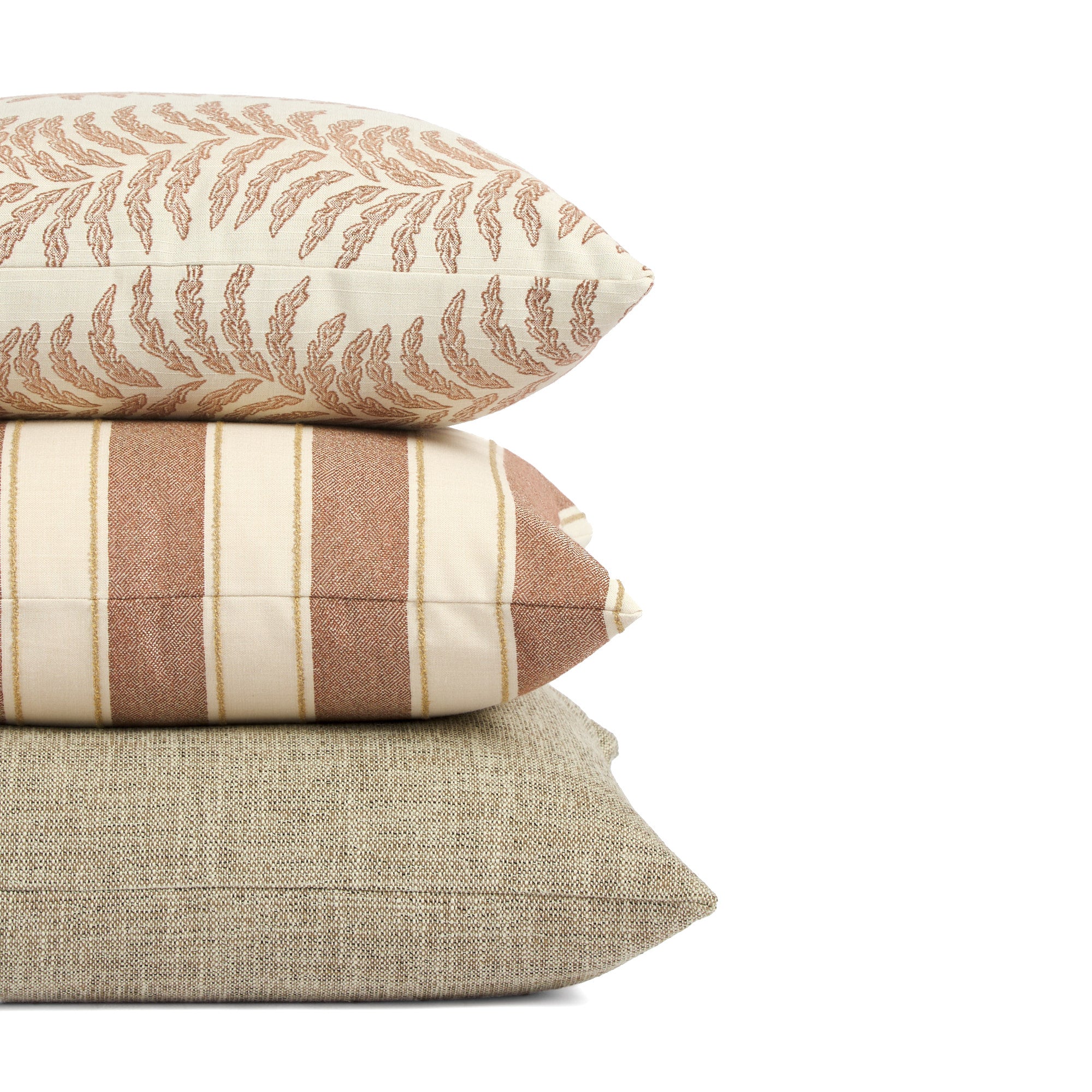 Stack of Tonic Living outdoor pillows including Swoon Terracotta, Sentiment Terracotta, and Troy Tweed in warm tones.
