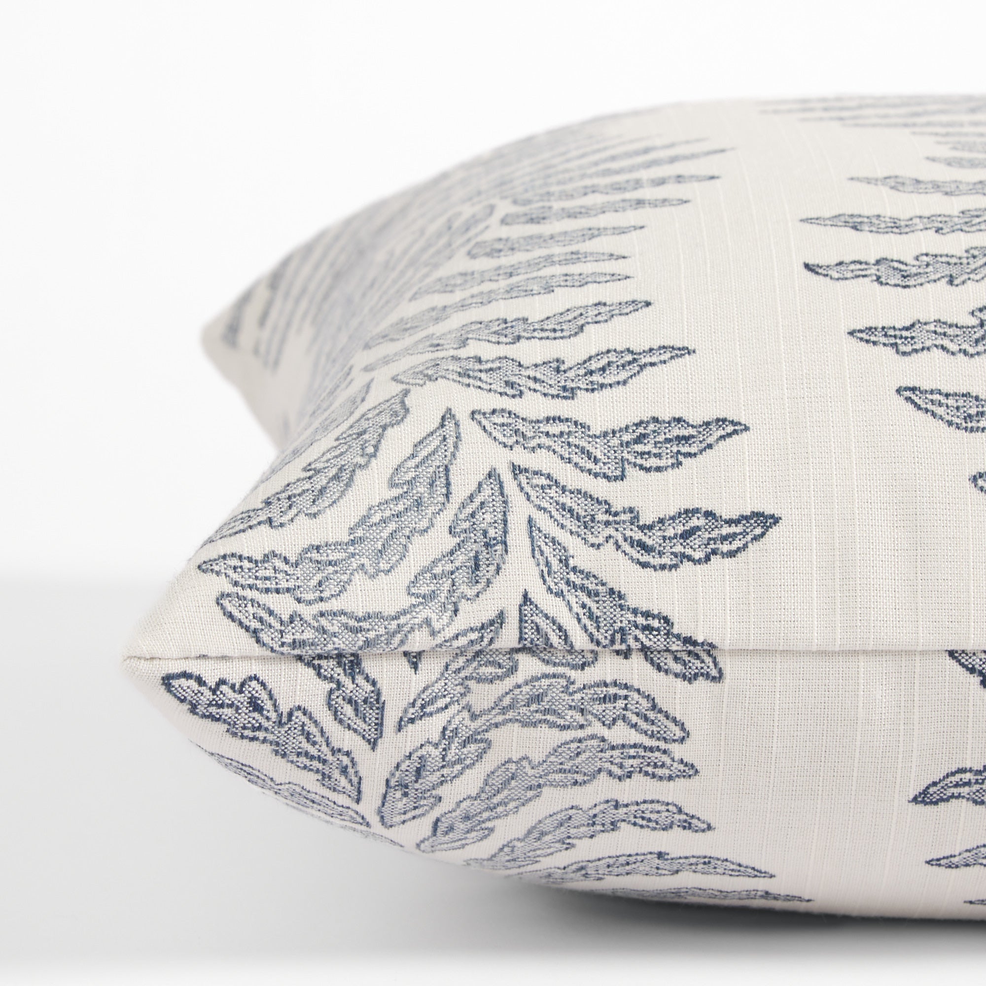 Side view of Tonic Living Swoon Denim decorative cushion highlighting its flowing blue botanical stripe design.