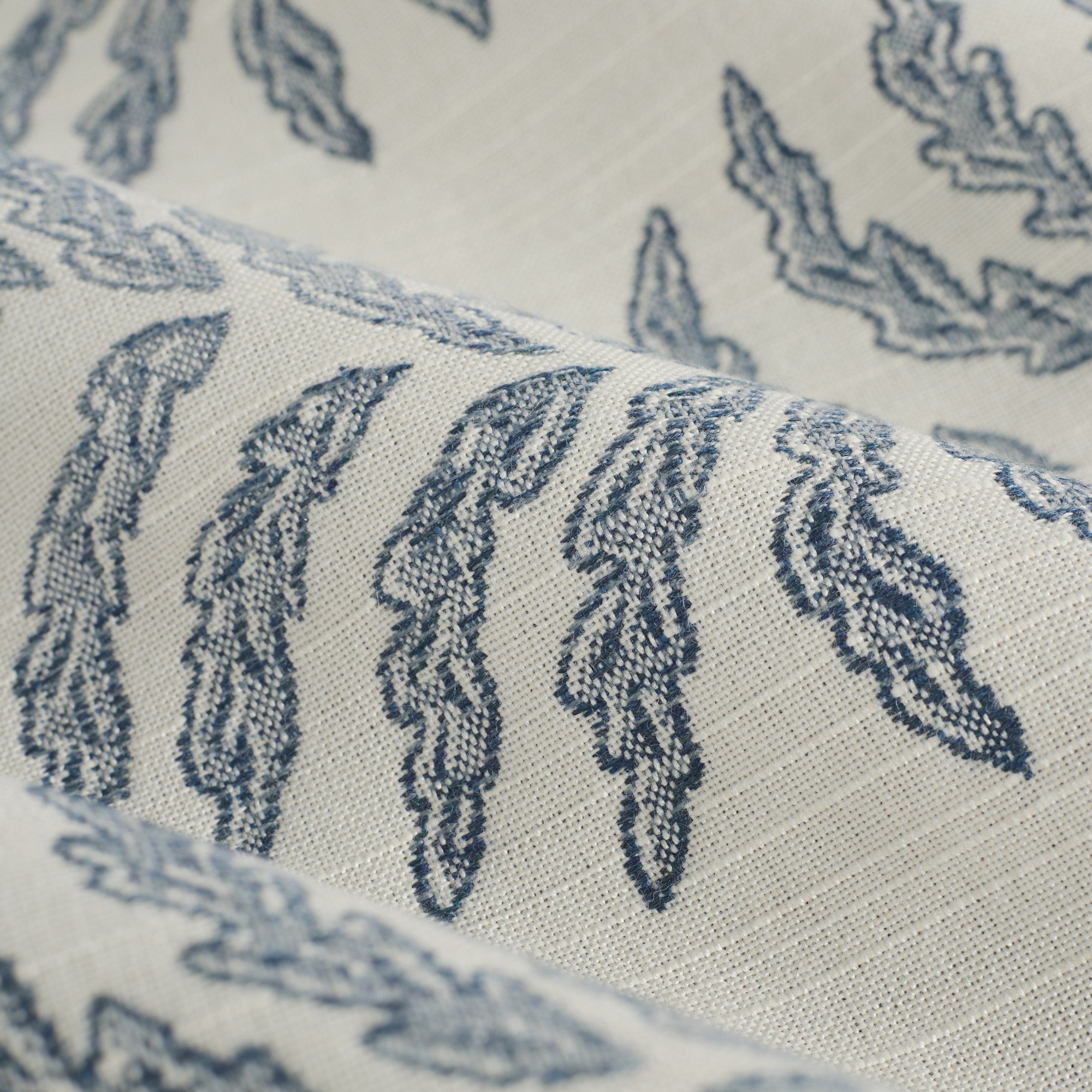 Close up of Tonic Living Swoon Sunbrella Denim fabric showing stylized fern stripe in blue and white.