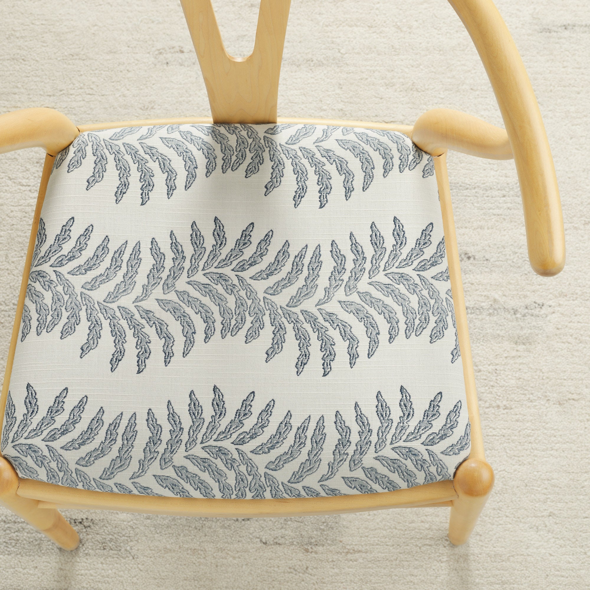 Tonic Living Swoon Sunbrella Denim indoor/outdoor upholstery fabric on a dining chair seat in blue and white fern stripe.