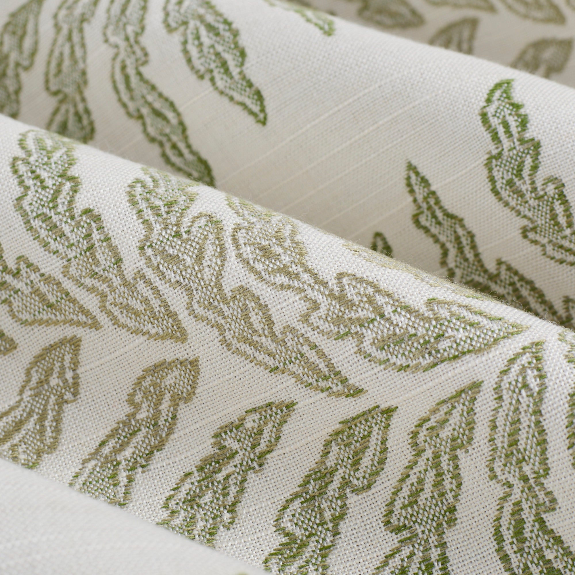 Close up of Tonic Living Swoon Sunbrella Sage fabric showing green and white botanical stripe detail.