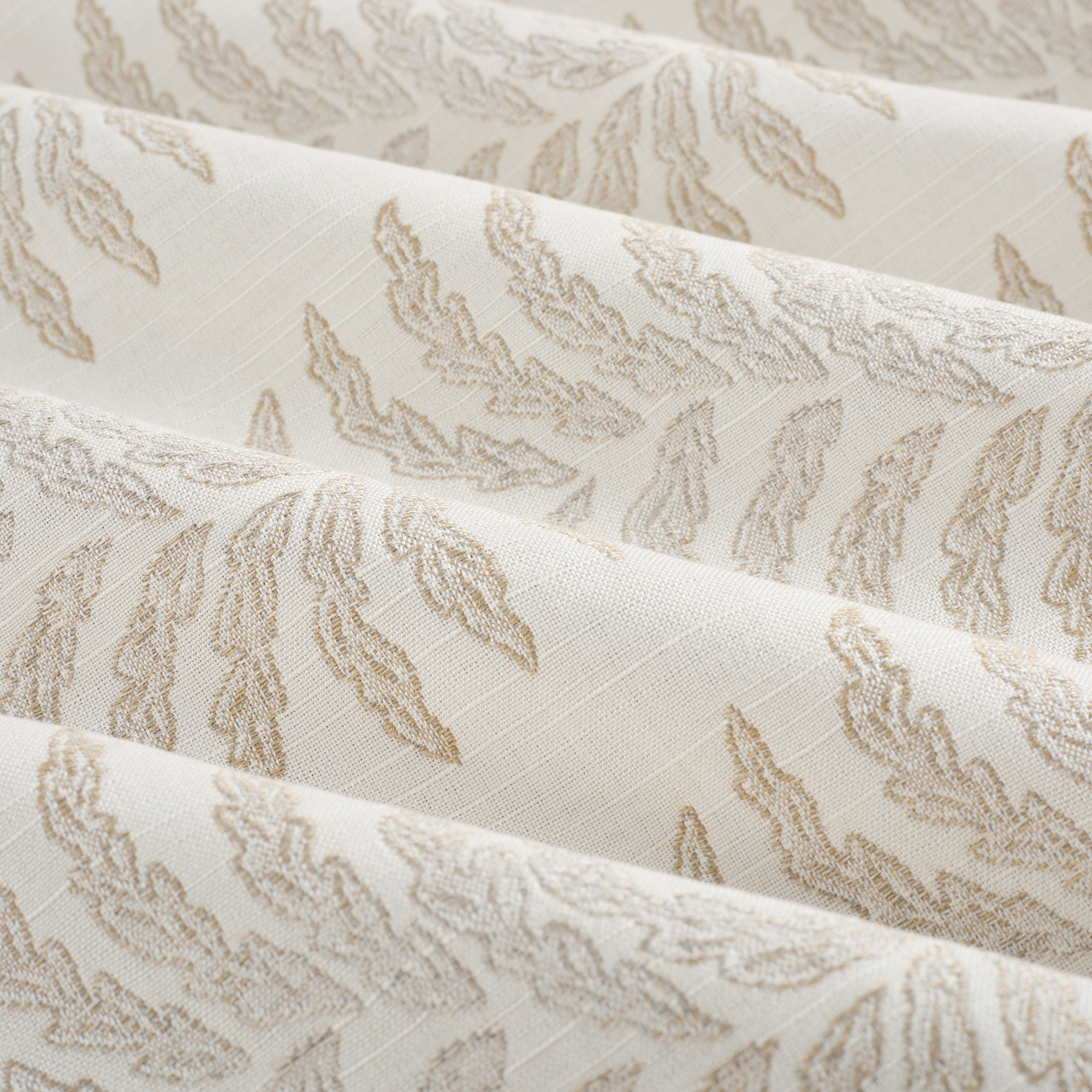 Tonic Living Swoon Sunbrella Sand performance fabric showing soft drape and movement in a beige botanical stripe.