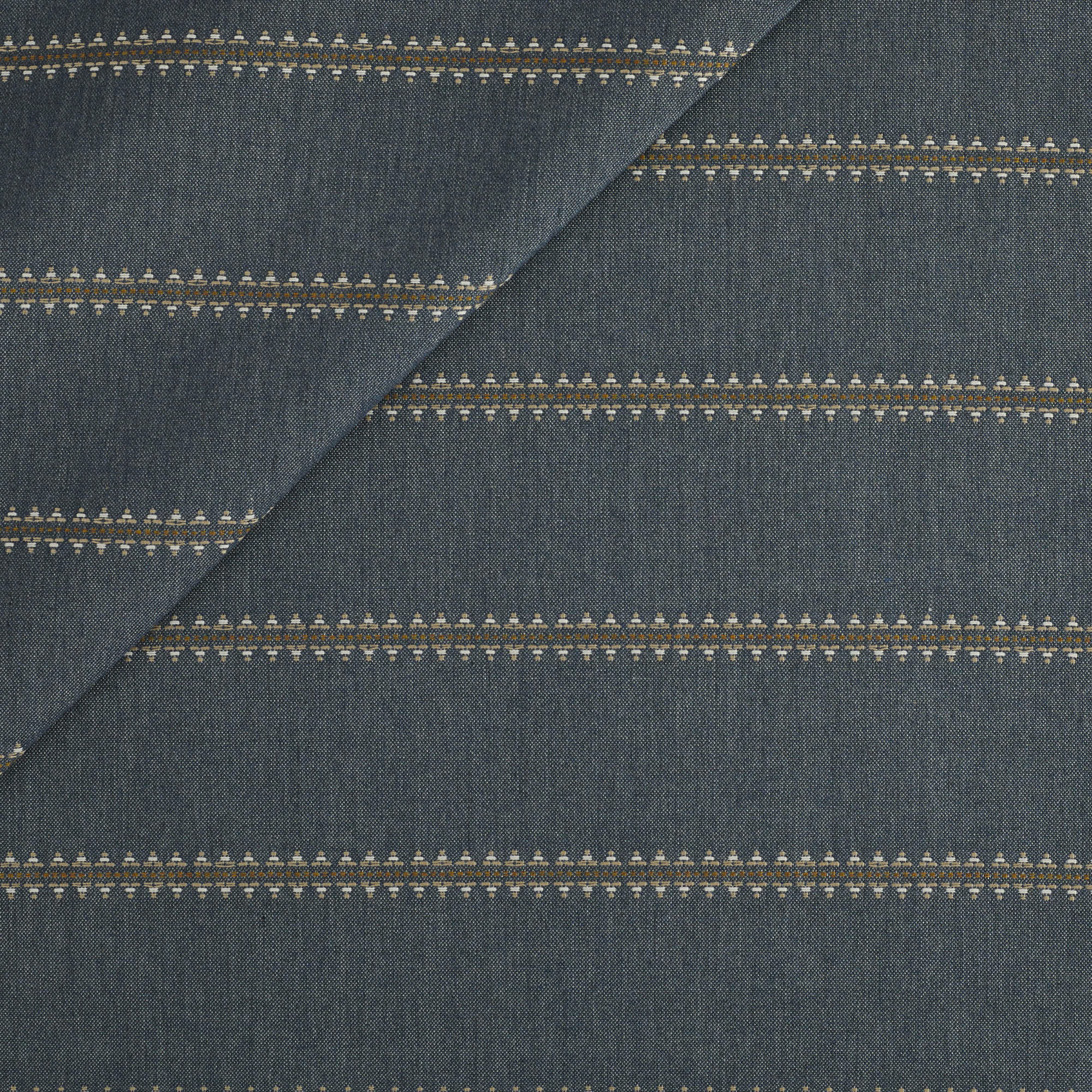 Tonic Living Talisman Sunbrella Outdoor Fabric in Denim, a dark blue indoor/outdoor upholstery fabric with an embroidered geometric stripe.