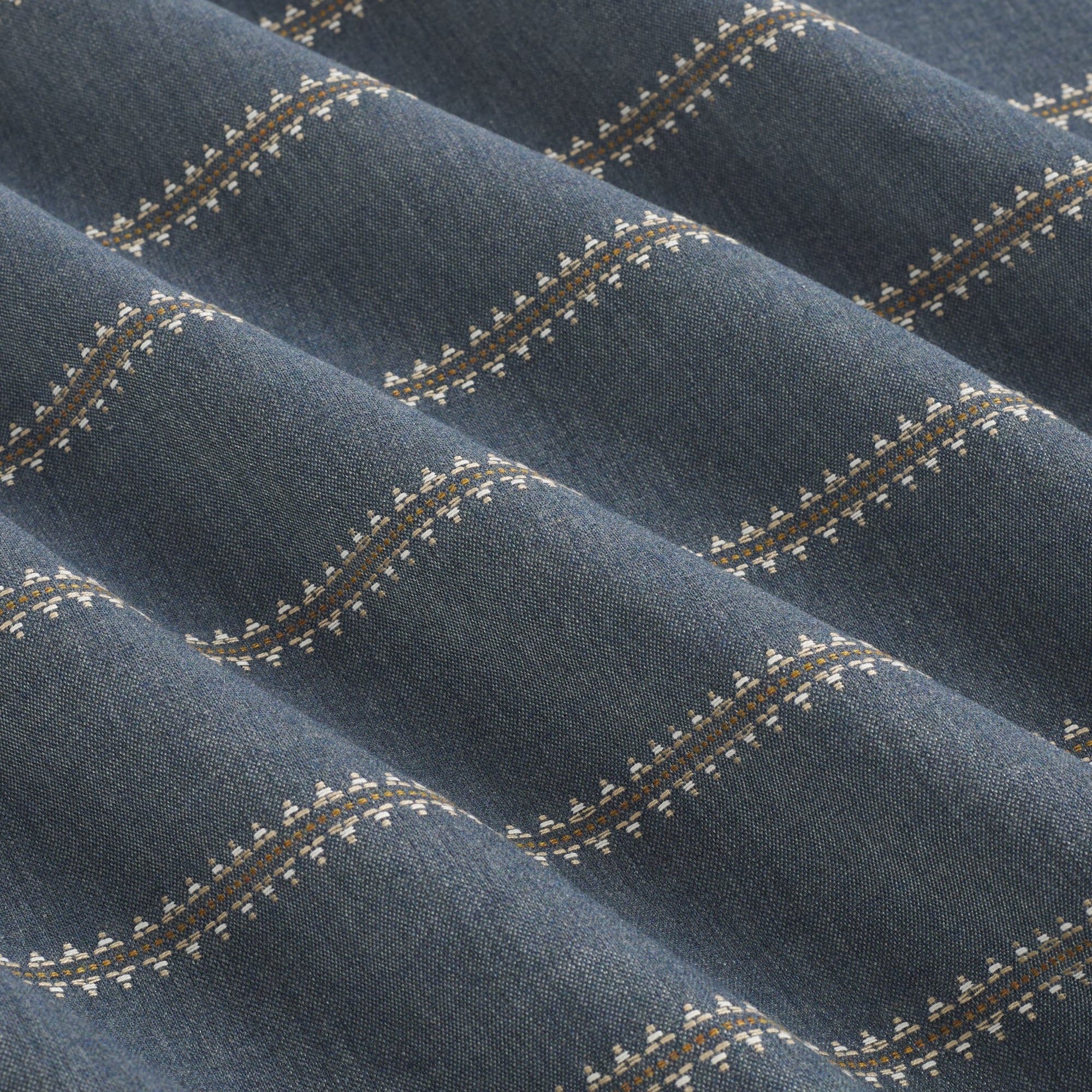 Tonic Living Talisman Sunbrella Denim blue indoor/outdoor upholstery fabric with a refined geometric stripe on a dark blue base.