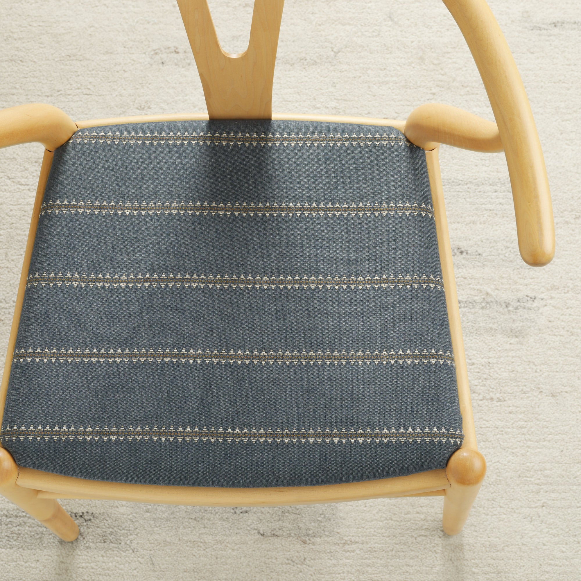 Tonic Living Talisman Sunbrella Denim blue indoor/outdoor upholstery fabric on a dining chair seat with a textured geometric stripe.