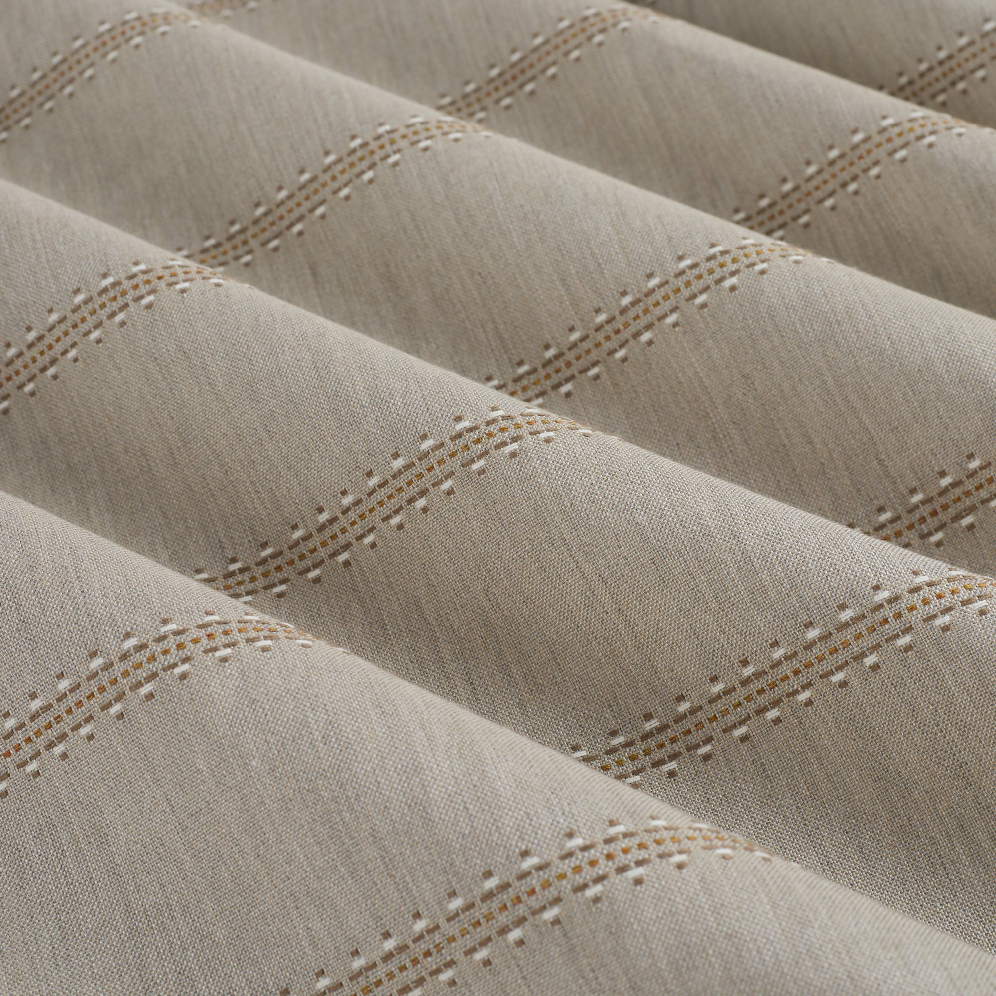 Tonic Living Talisman Sunbrella Sand performance fabric showing soft drape and movement in a neutral embroidered stripe.