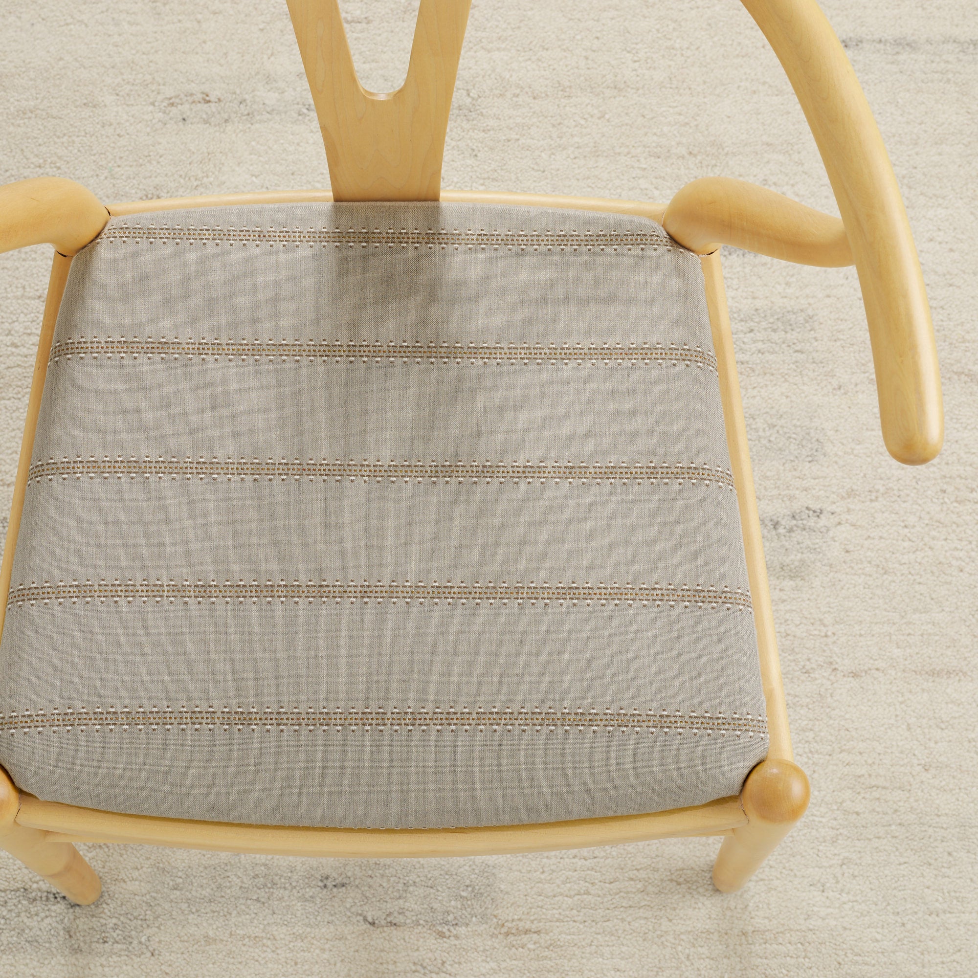 Tonic Living Talisman Sunbrella Sand indoor/outdoor upholstery fabric on a dining chair seat in sand and taupe stripe.