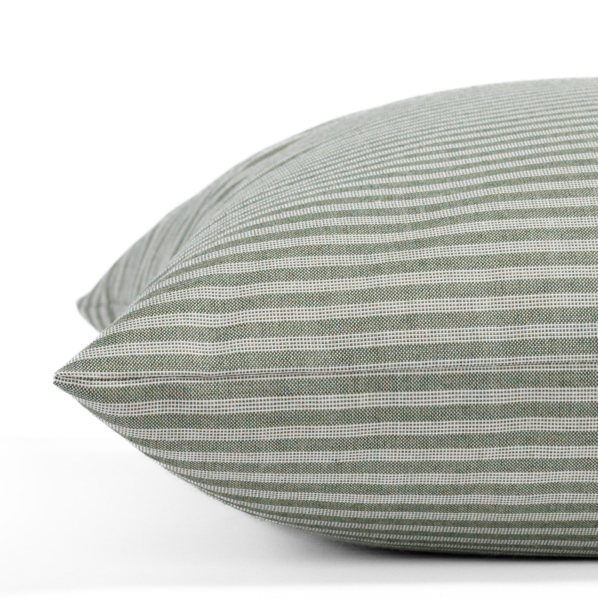 A sage green and beige ticking stripe pattern indoor/outdoor pillow from Tonic Living: close-up side view.