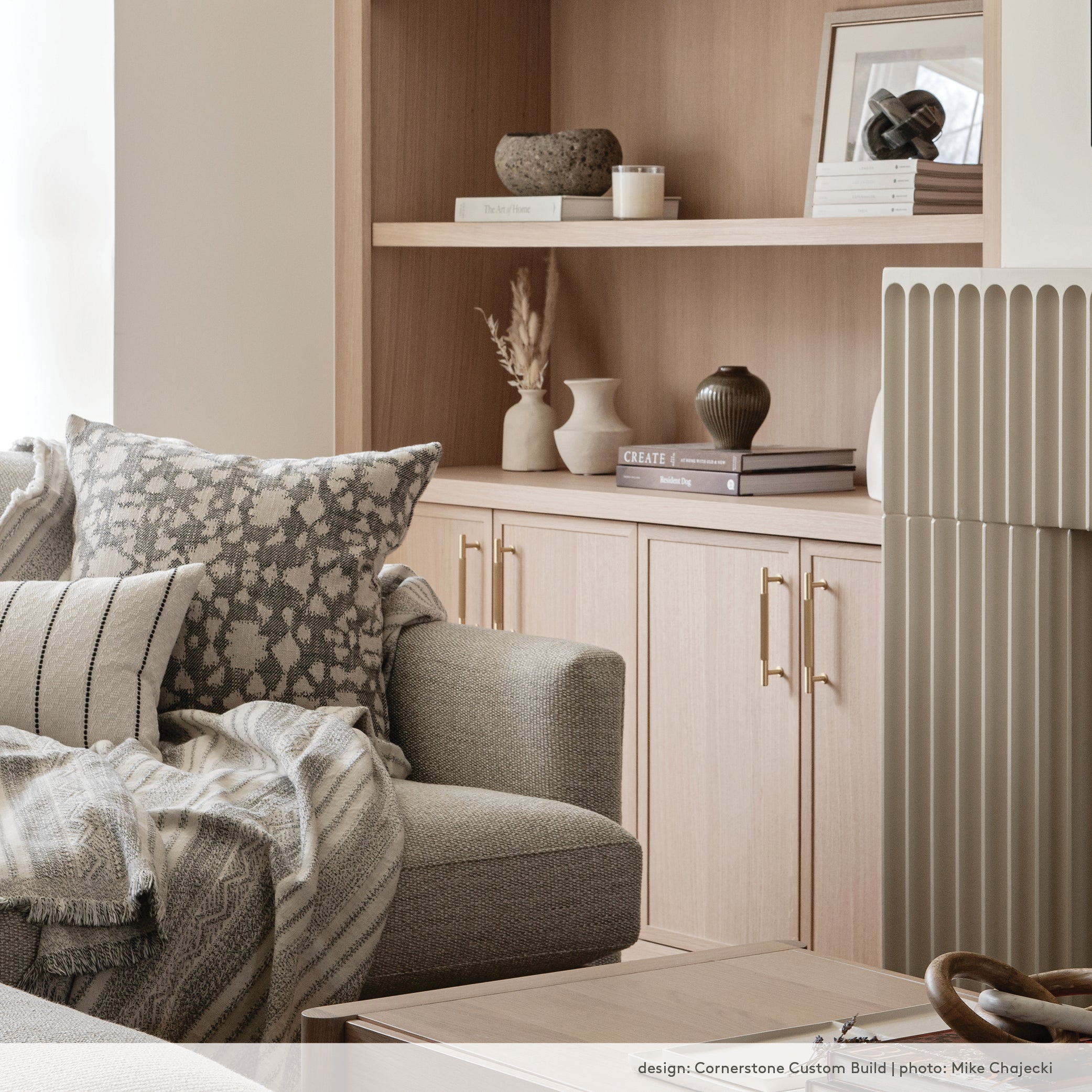 black and white cotton throw blanket in an organic modern living room with white oak built-in shelves and a light grey couch.