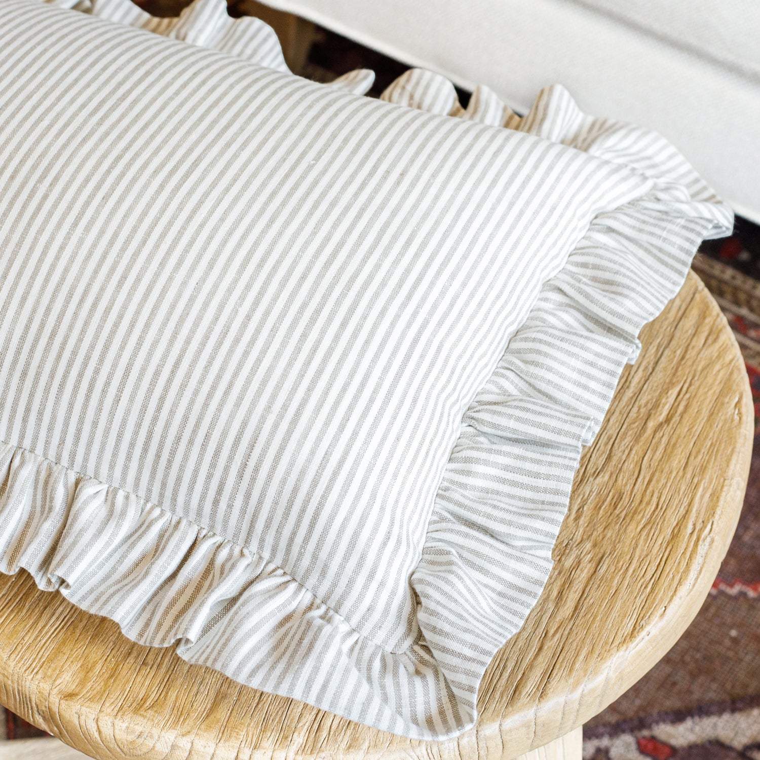 Siena Buff ruffled pillow styled on a stool, showing its lightweight structure, classic vertical stripes, and romantic charm—perfect for cottage, farmhouse, or kids' rooms.