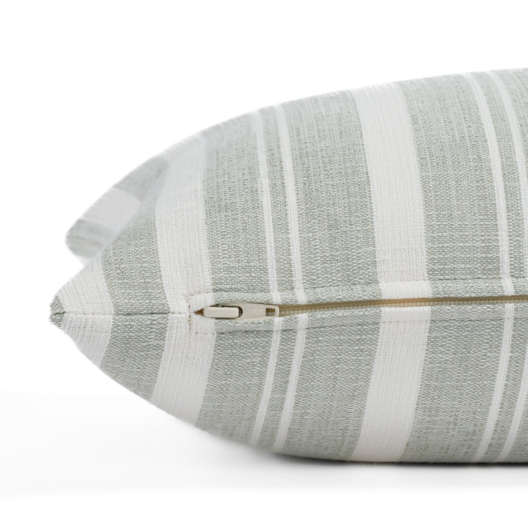 A light green and white striped throw pillow from Tonic Living: close-up zipper view.