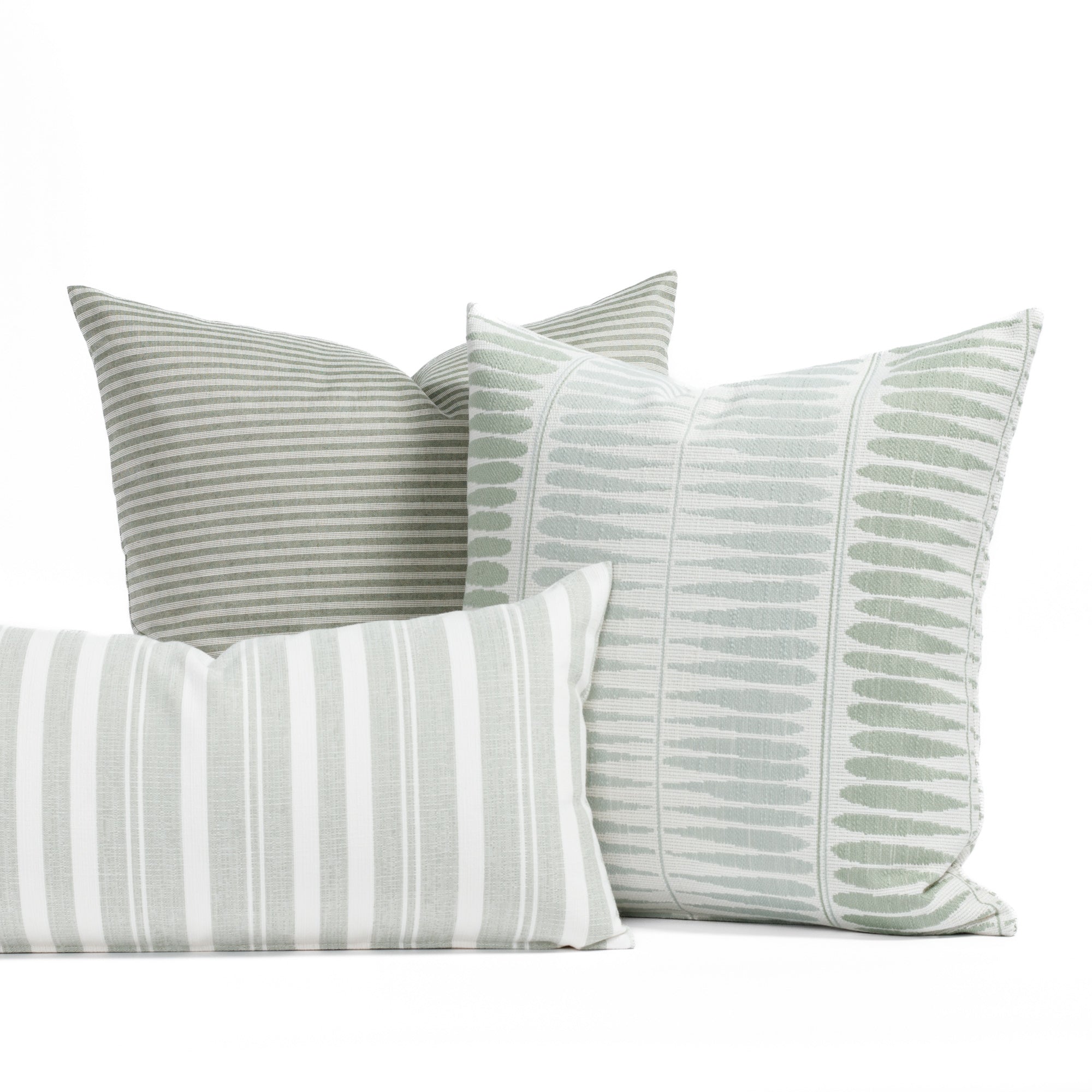 A selection of soft sage green, misty aqua and white indoor/outdoor throw pillows from Tonic Living.
