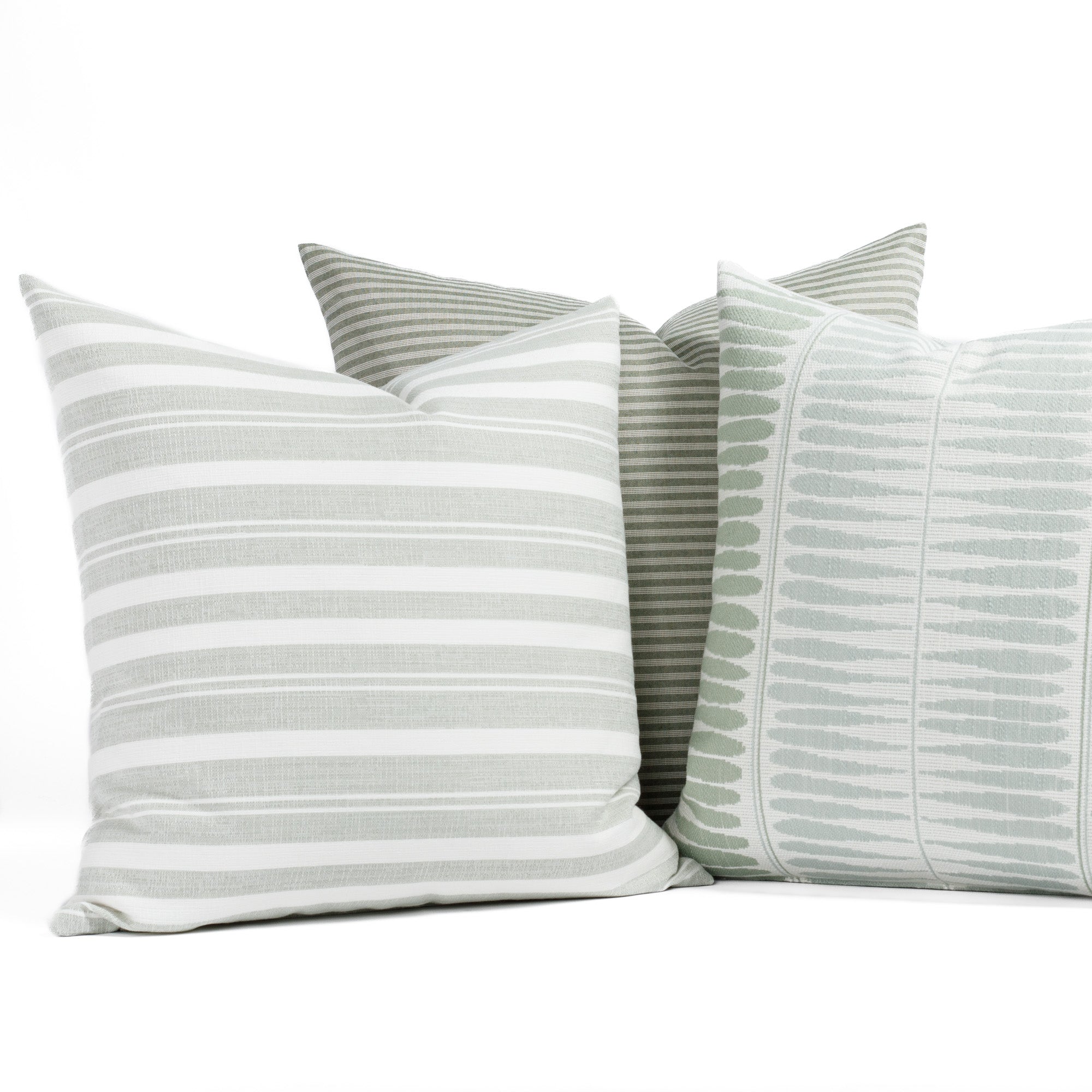 A selection of soft sage green, aqua and white indoor/outdoor throw pillows from Tonic Living.