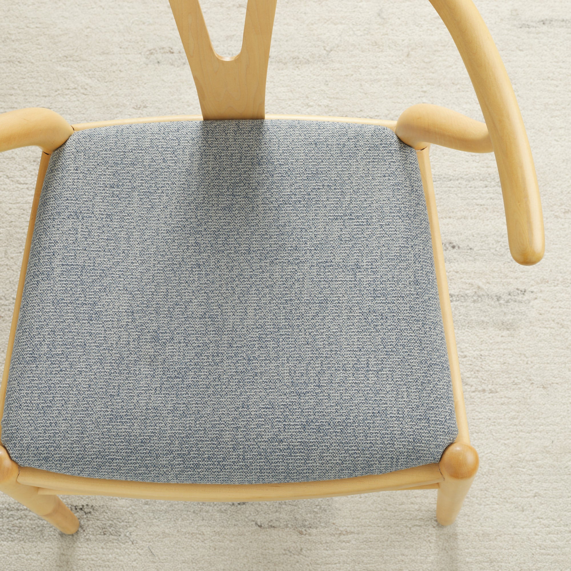 Tonic Living Troy InsideOut Denim indoor/outdoor upholstery fabric on a dining chair seat in textured blue fabric.