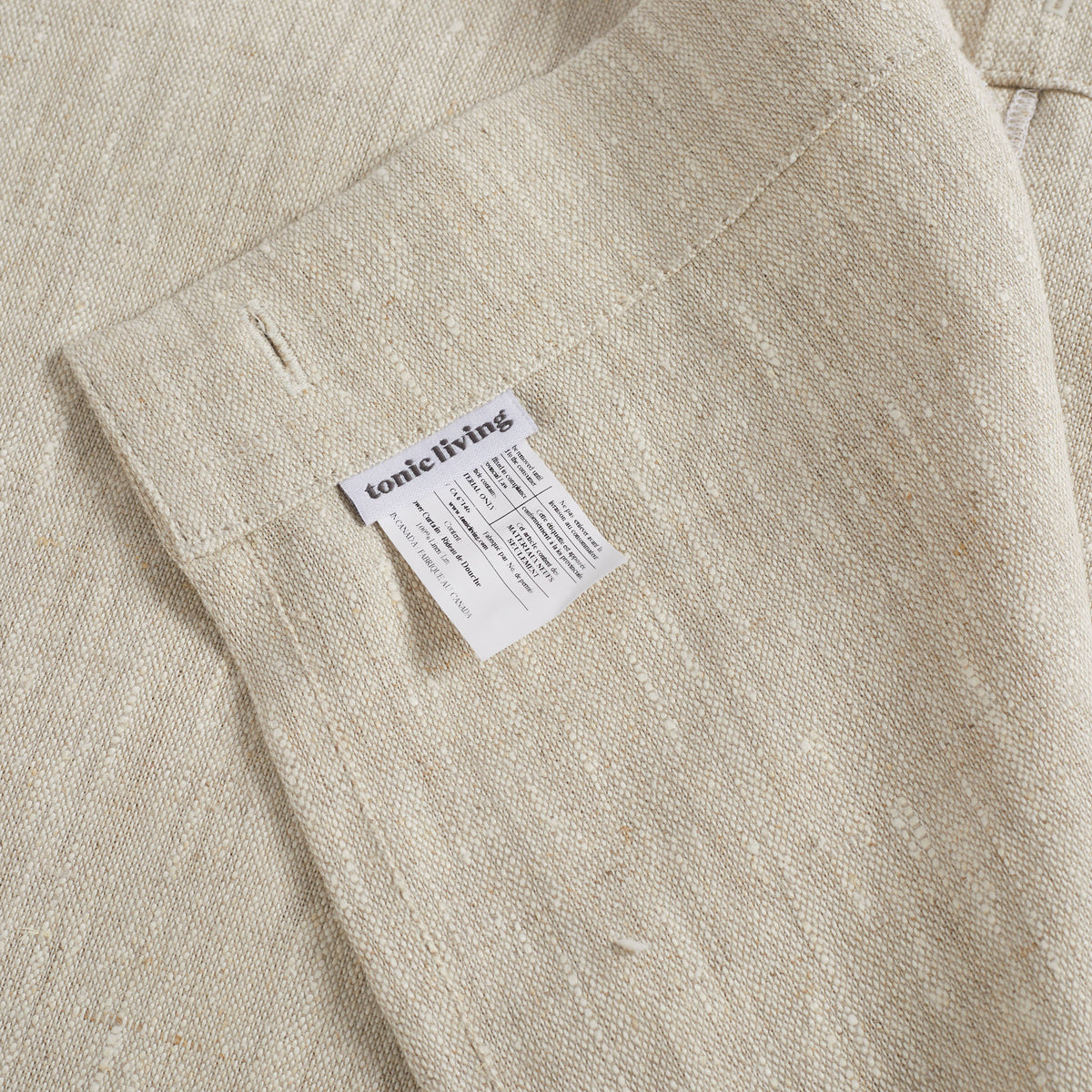 Inside top hem of Tonic Living Tuscany Linen Shower Curtain in Oatmeal Slub showing the buttonhole top construction and Tonic Living label.