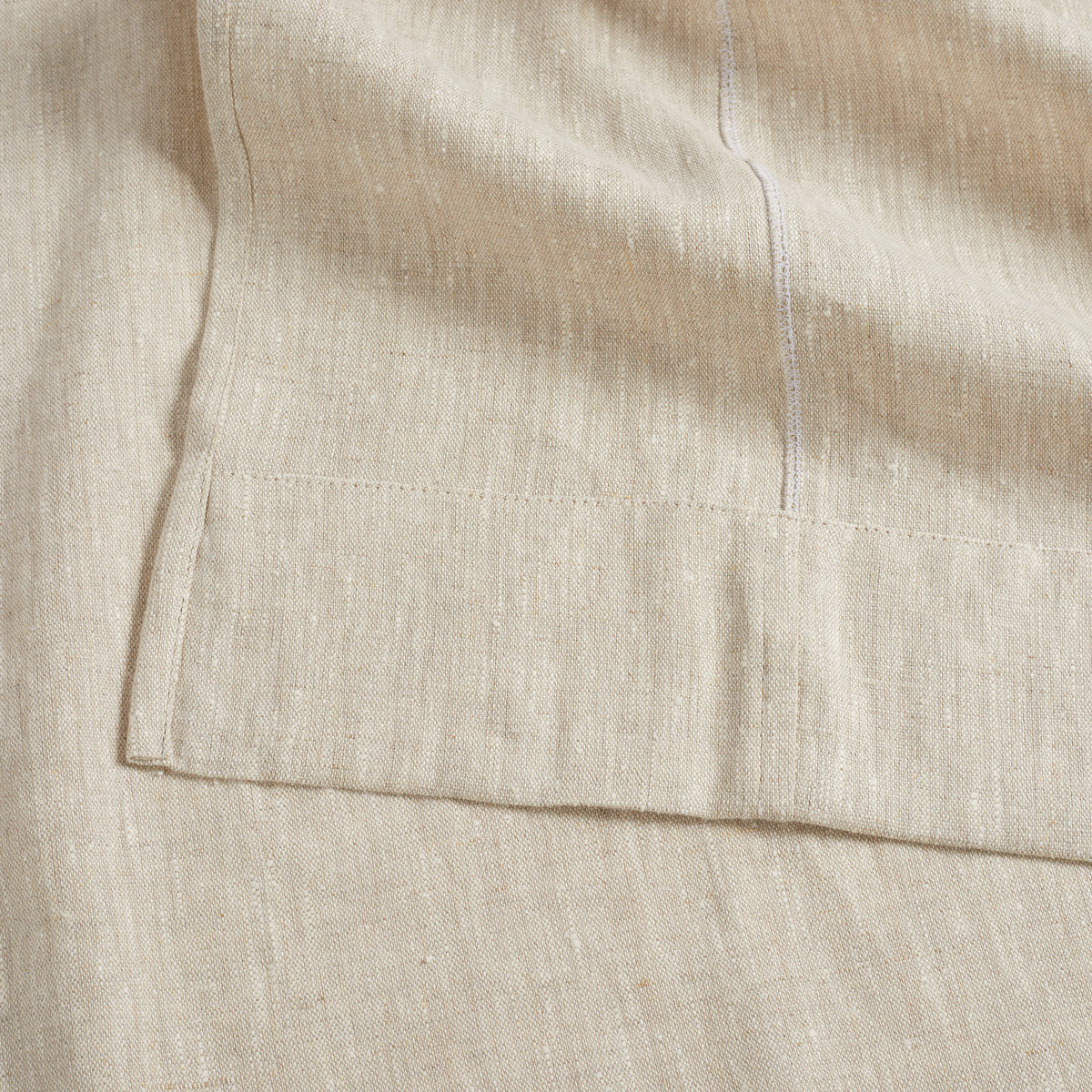 Close up of Tonic Living Tuscany Linen Shower Curtain in Oatmeal Slub showing its wide hem and oatmeal greige linen texture.