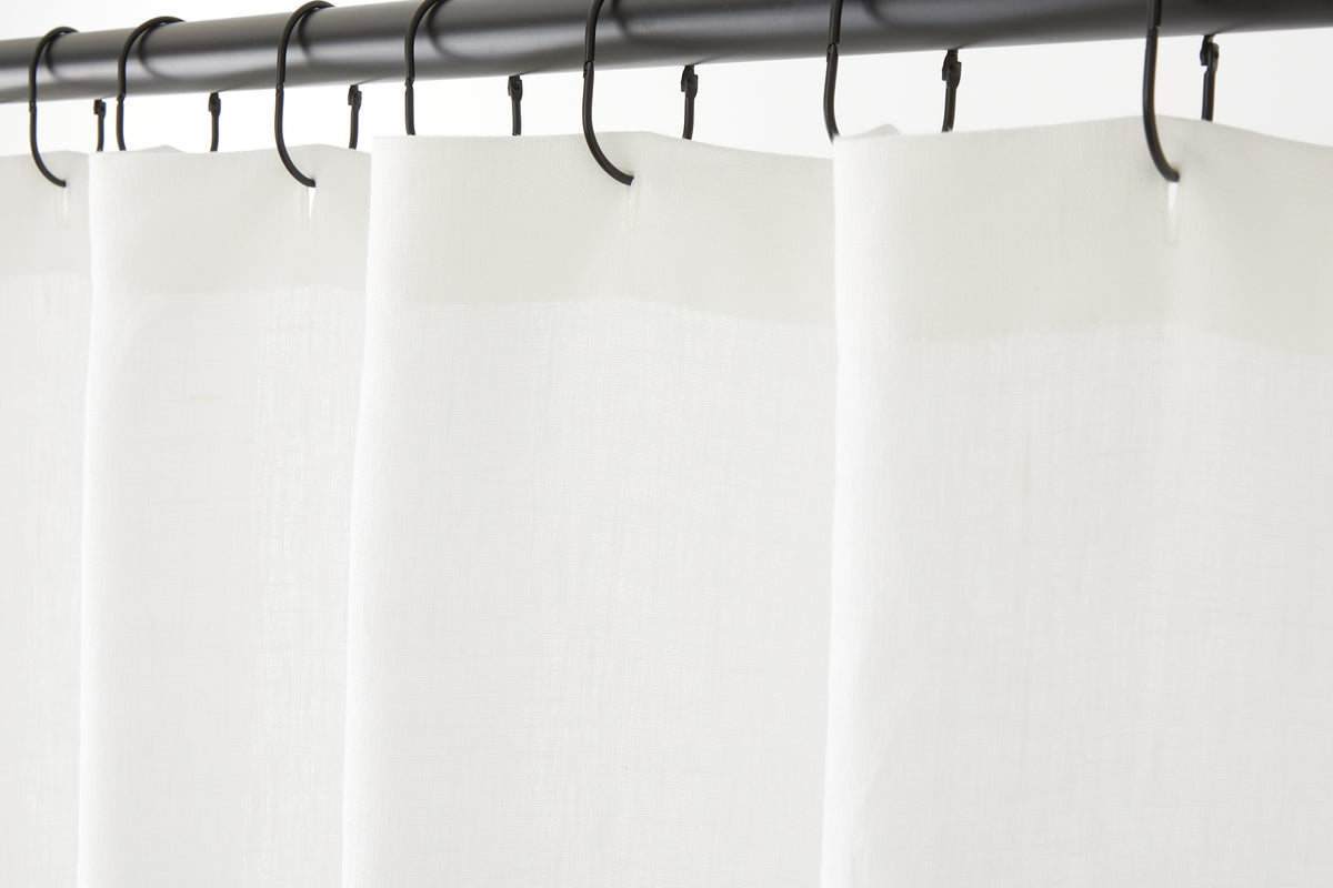 Tonic Living Tuscany Linen Shower Curtain in Oyster, a warm white linen shower curtain hanging from black curtain rings.