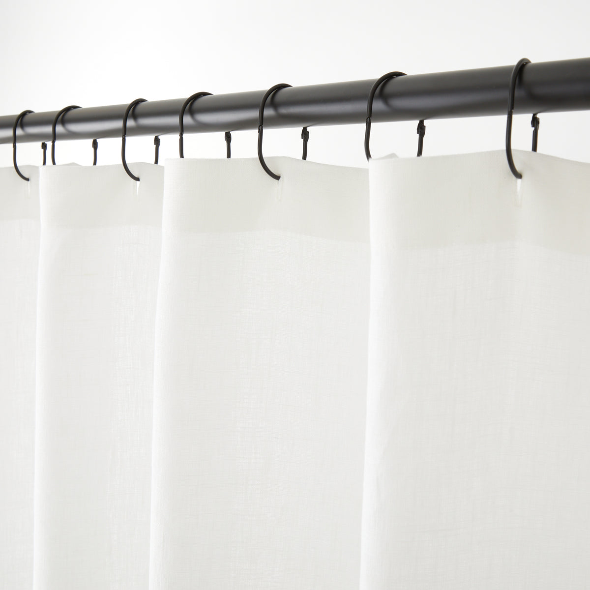 Tonic Living Tuscany Linen Shower Curtain in Oyster, a warm white linen shower curtain hanging from black curtain rings.