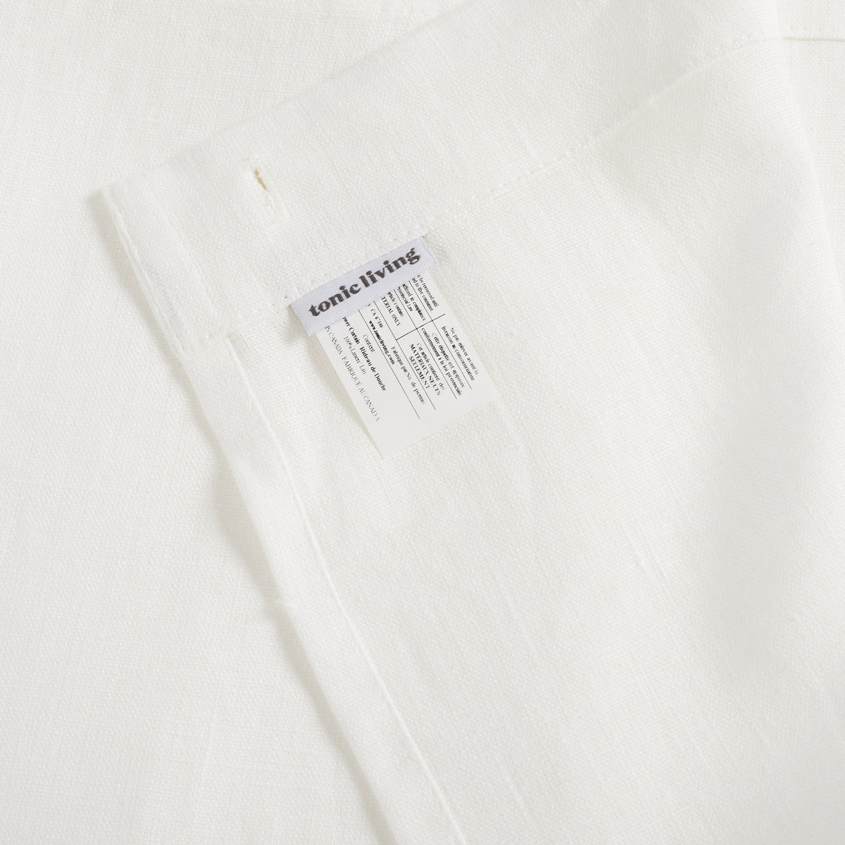 Inside top hem of Tonic Living Tuscany Linen Shower Curtain in Oyster showing the buttonhole top construction and Tonic Living label.