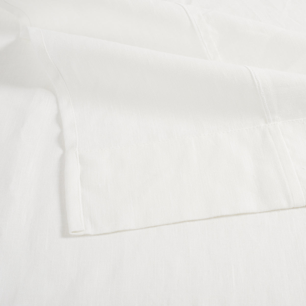 Close up of Tonic Living Tuscany Linen Shower Curtain in Oyster showing its wide hem and creamy ivory linen texture.