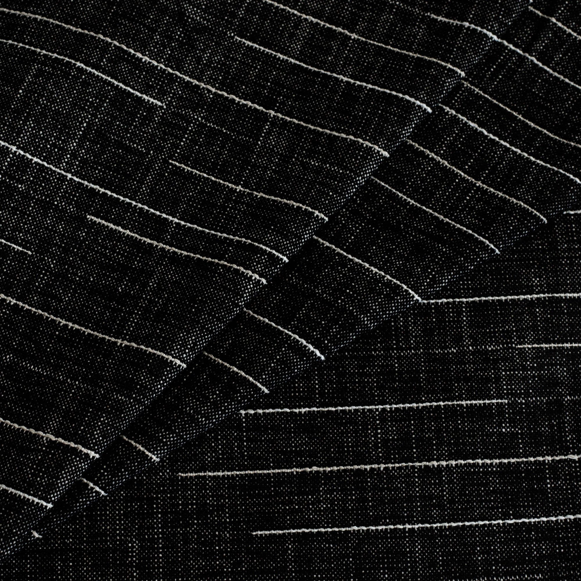 Yuzu InsideOut Onyx, a black and white upholstery fabric from Tonic Living with raised contrasting threads.