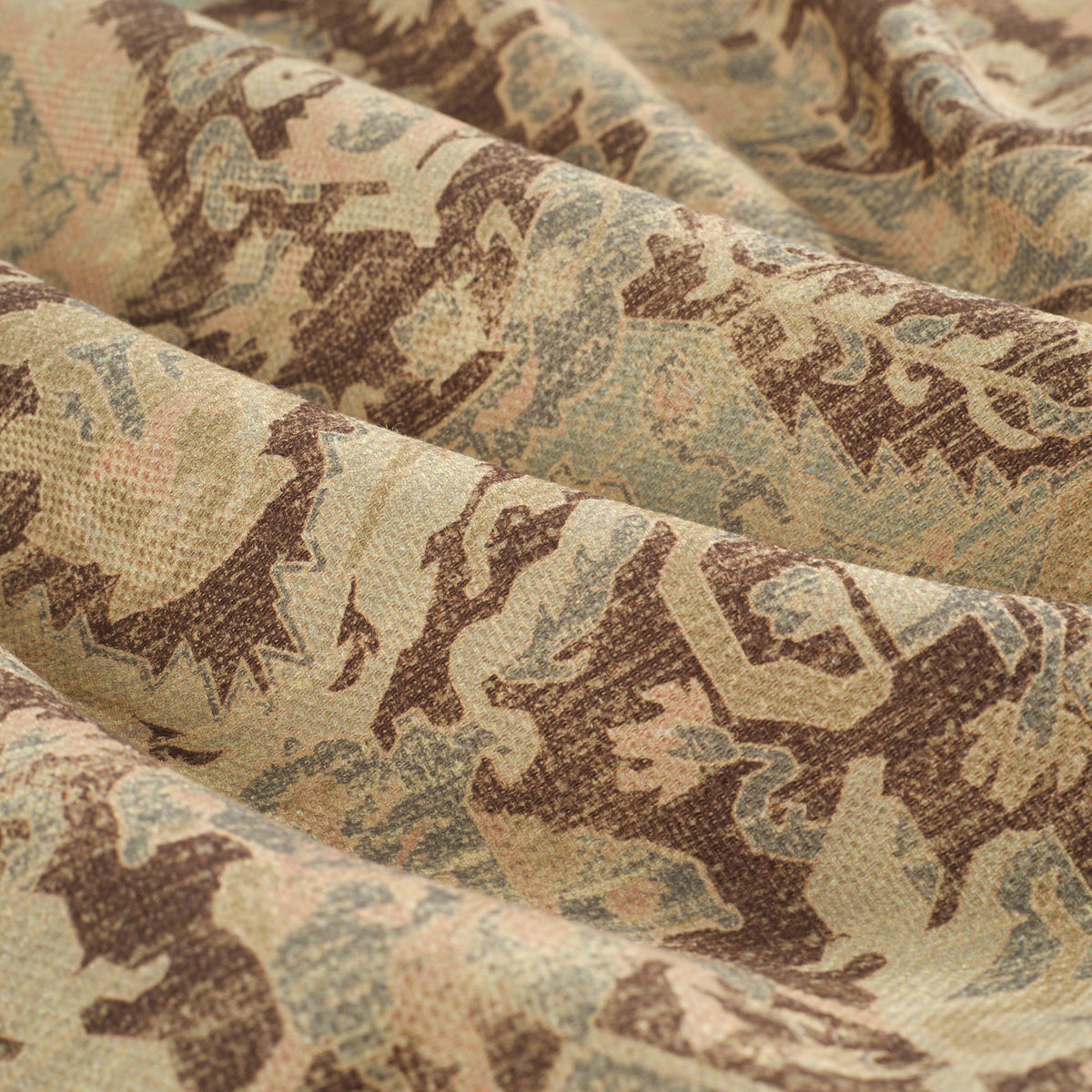 Close up of Tonic Living Zuri Driftwood fabric showing a faded medallion pattern in brown, beige, dusty blue, and blush pink.