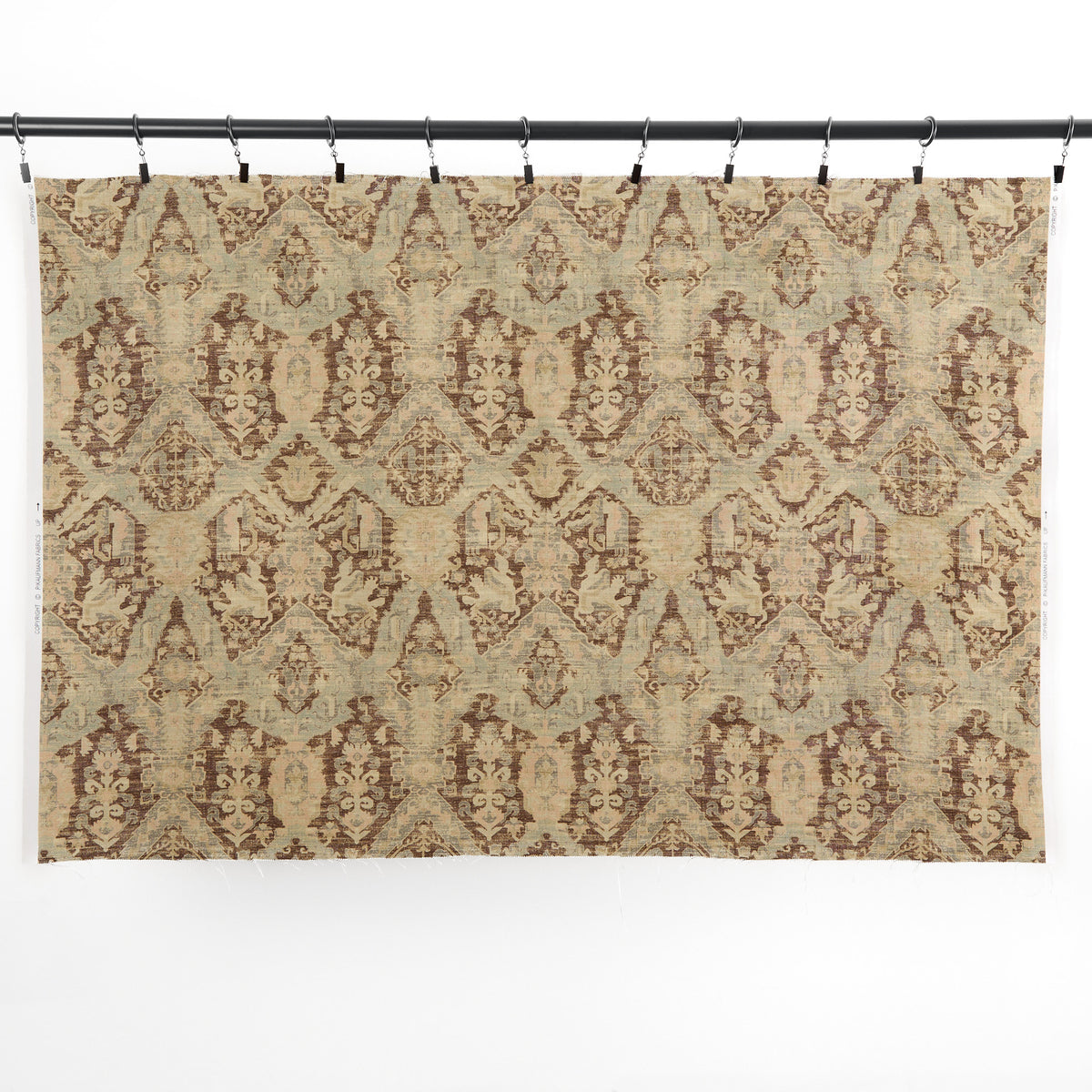 One yard of Tonic Living Zuri Driftwood multi-use fabric hanging from clips, showing the full ornamental medallion pattern.