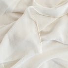 an oyster white sheer curtain fabric with a weighted selvage edge