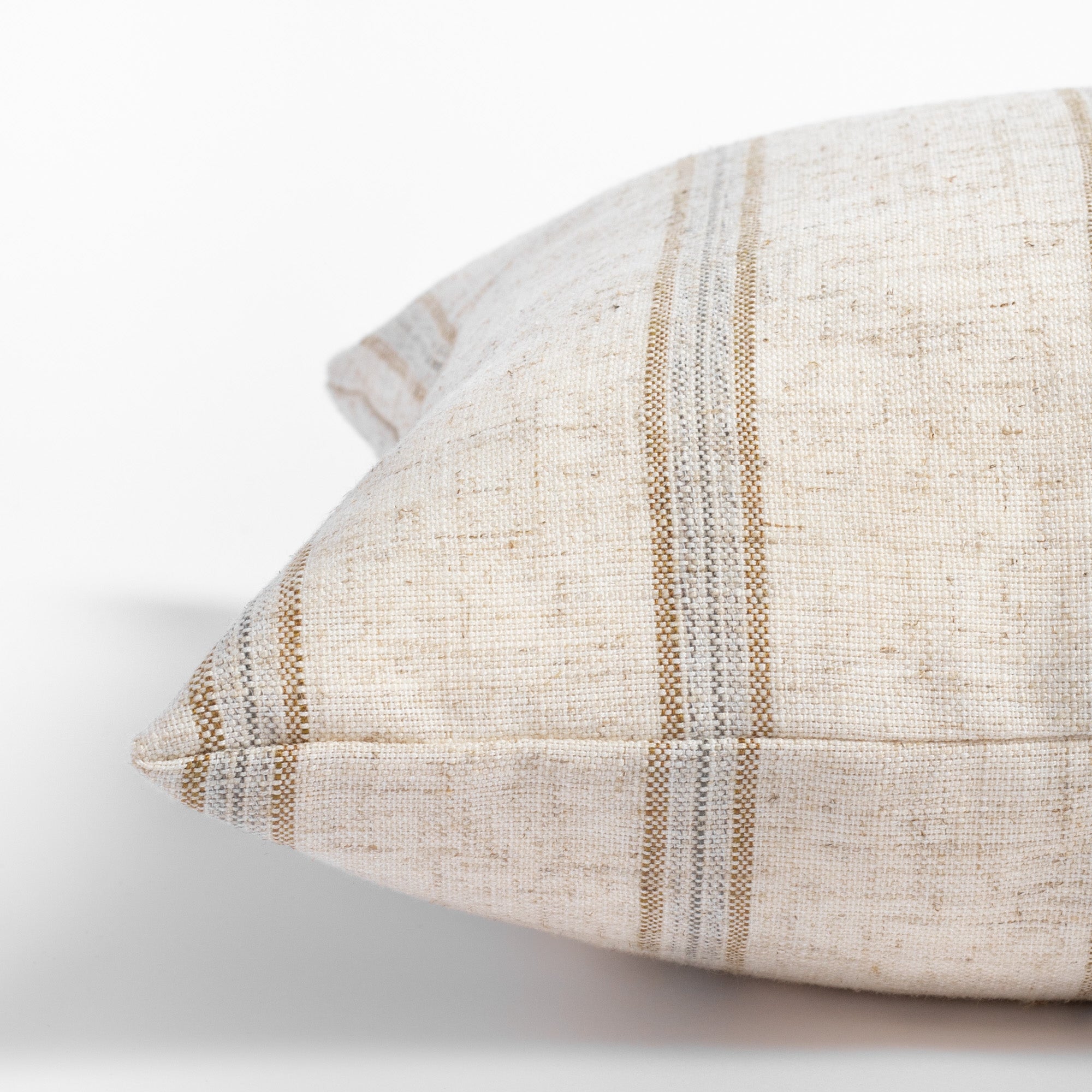 Yarmouth Stripe Sandstone, a beige lumbar pillow with golden sand and grey vertical stripes : close up side view