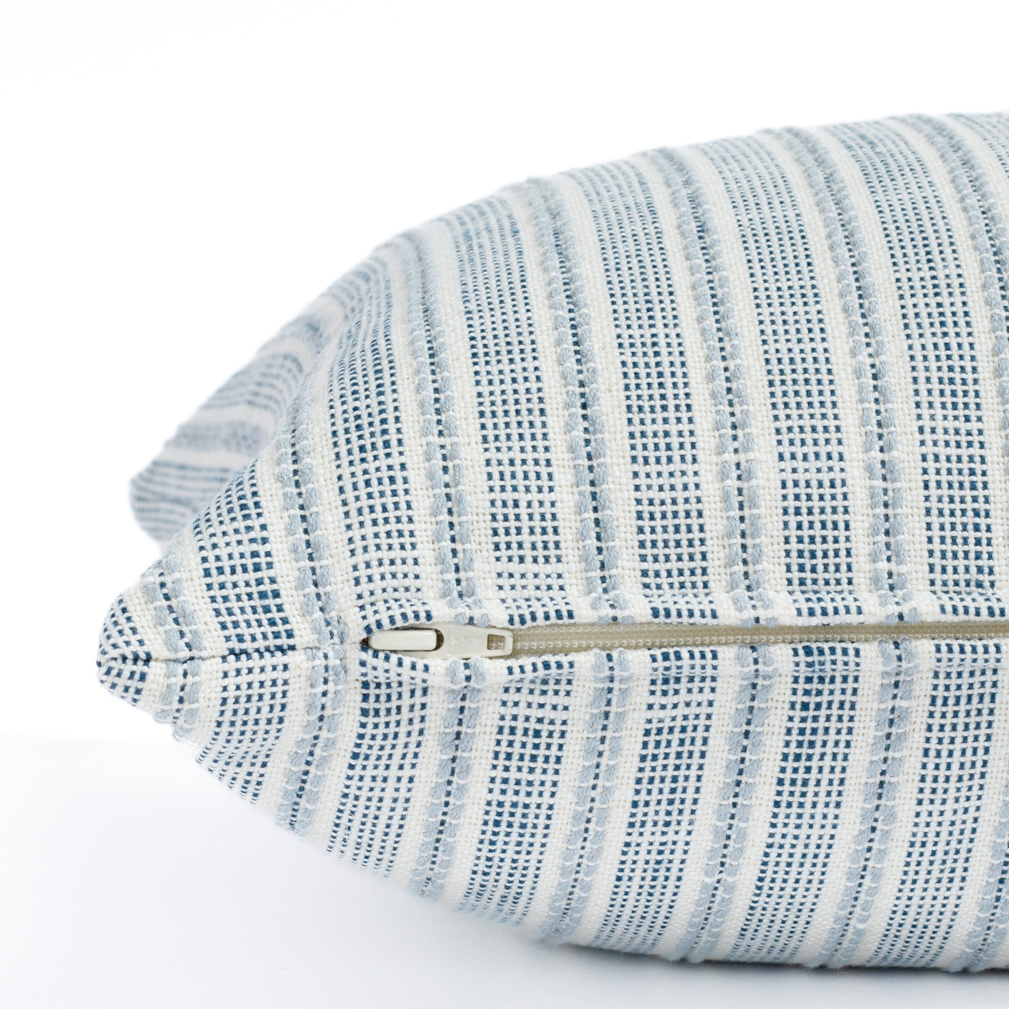 a white and blue outdoor throw pillow : close up zipper view