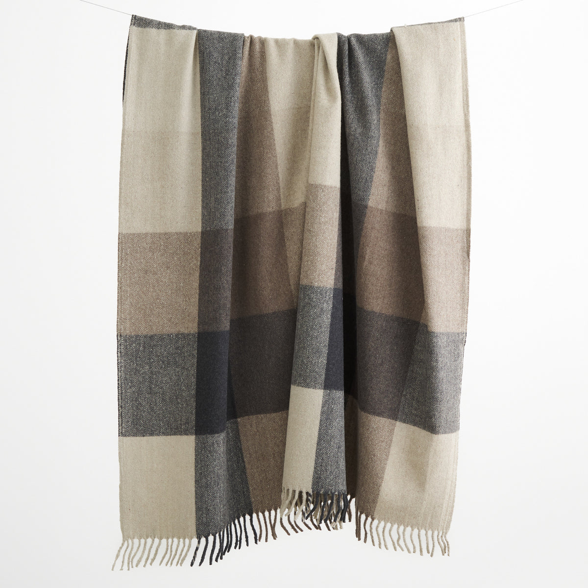Tonic Living Angus Check Wool Throw Blanket in Mink, a brown, grey, and beige checked wool blanket with fringed edges.