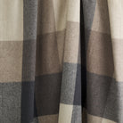 Close up of Tonic Living Angus Check Mink wool blanket showing its brown, grey, and sand check pattern with subtle herringbone texture.
