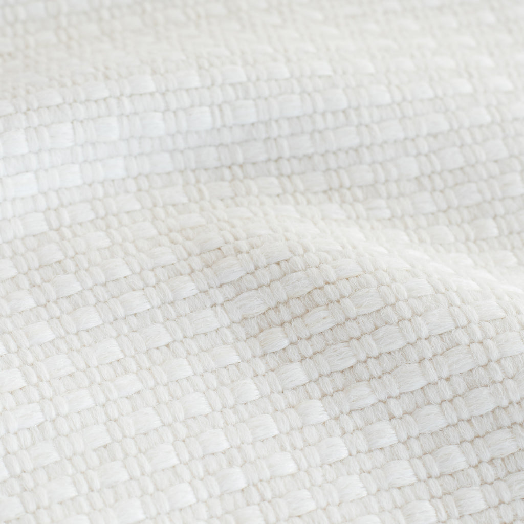 a white basket weave textured upholstery fabric : close up view