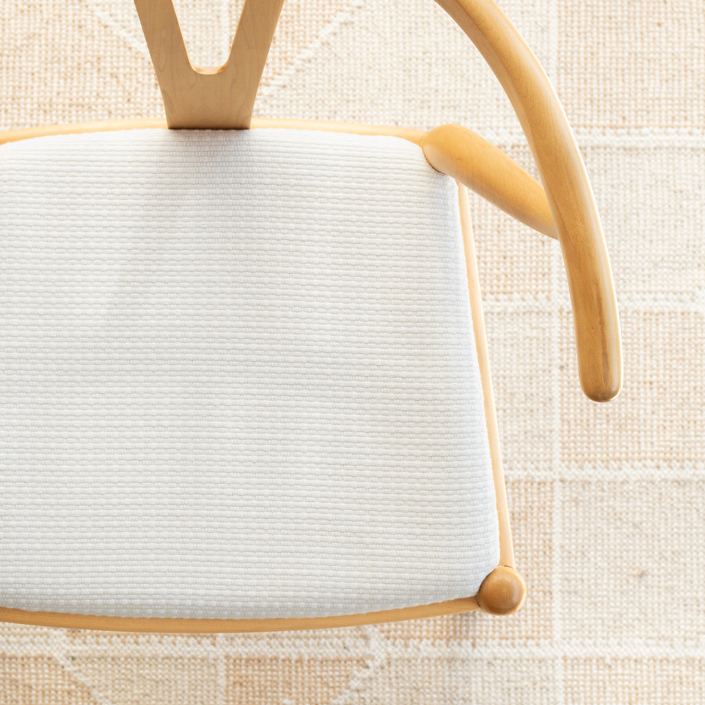 a white basket weave textured upholstered chair seat