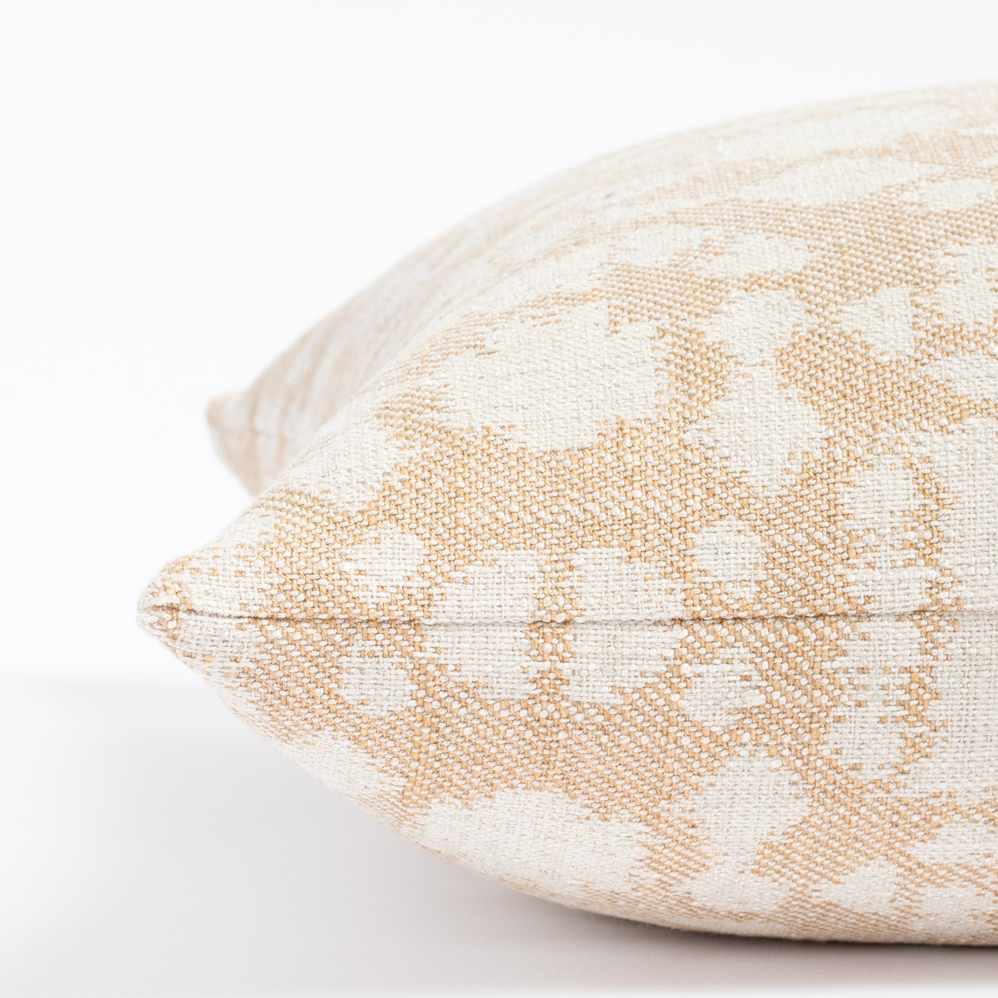 a warm gold and cream abstract botanical patterned throw pillow : close up side view