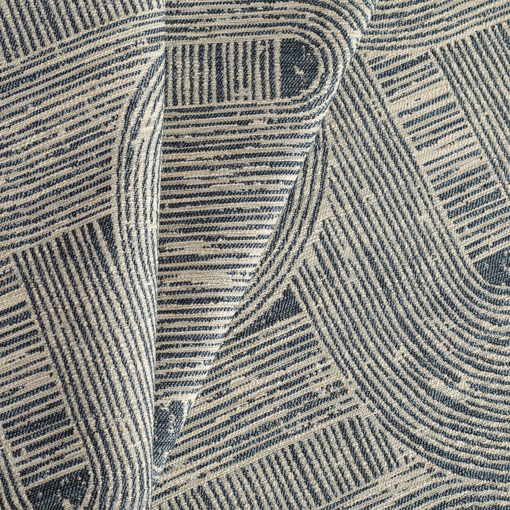 a geometic indigo blue and warm grey swirling patterned upholstery fabric: close up view 2