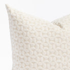 a plush white geometric quilted patterned pillow : close up view