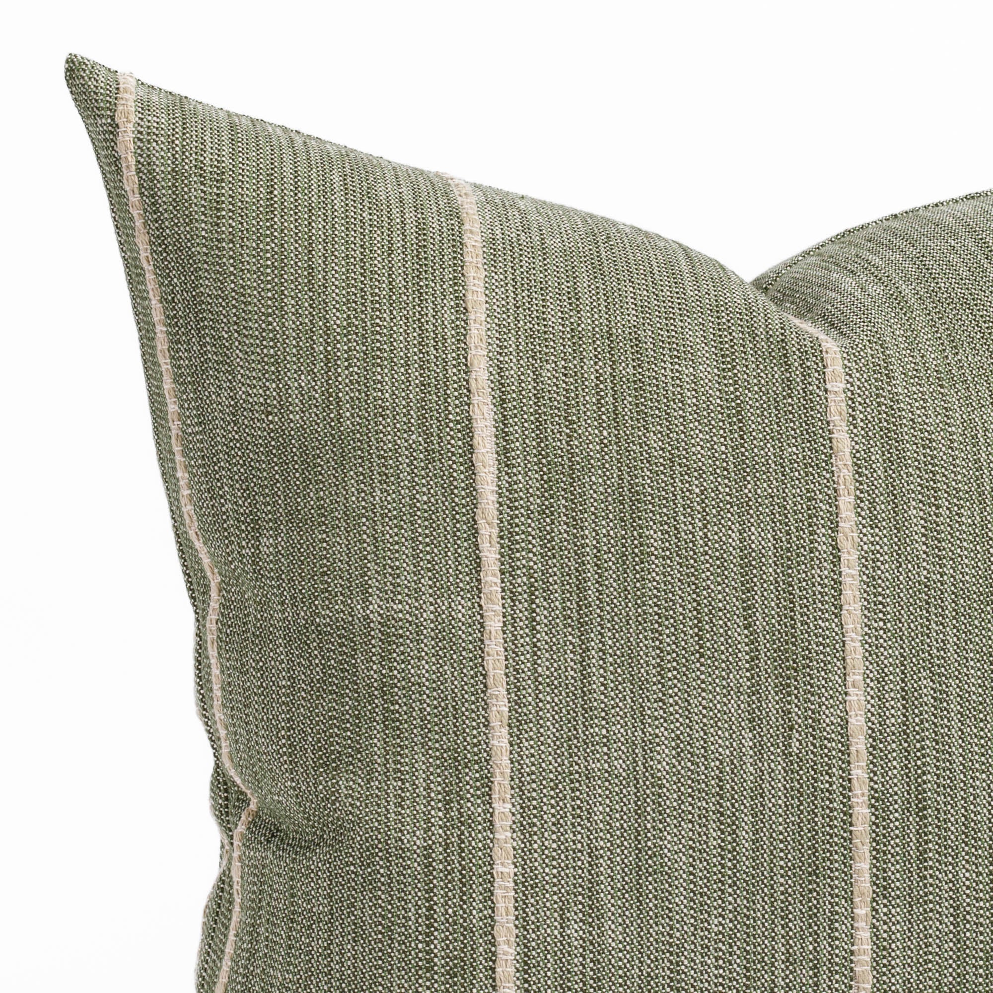 a leafy green throw pillow with a chunky natural stripe: close up view