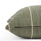 a leafy green throw pillow with a chunky natural stripe: close up zipper view