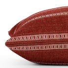 A red and white striped lumbar pillow: close up side view.