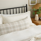 Cabot Plaid Sage, an extra large lumbar pillow from Tonic Living, styled on a bed.