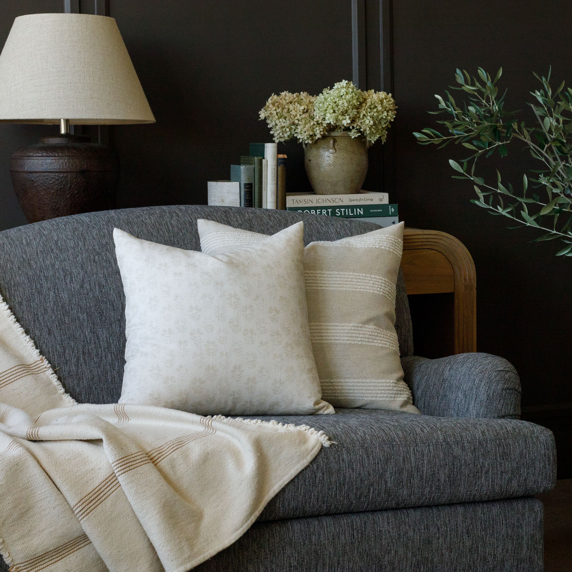 Tonic Living cream patterned throw pillows on a charcoal grey sofa