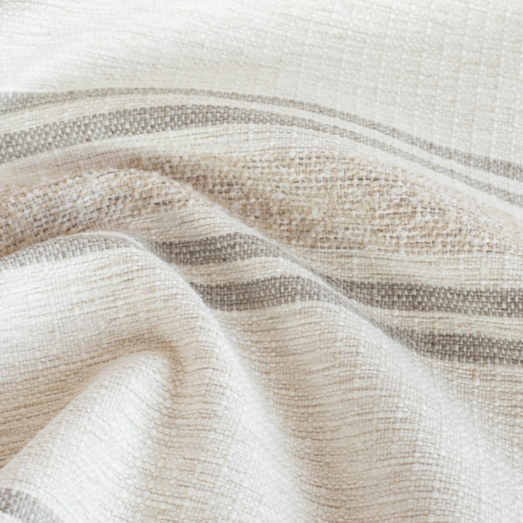 a white, cream and sandy taupe indoor outdoor striped fabric : close up view